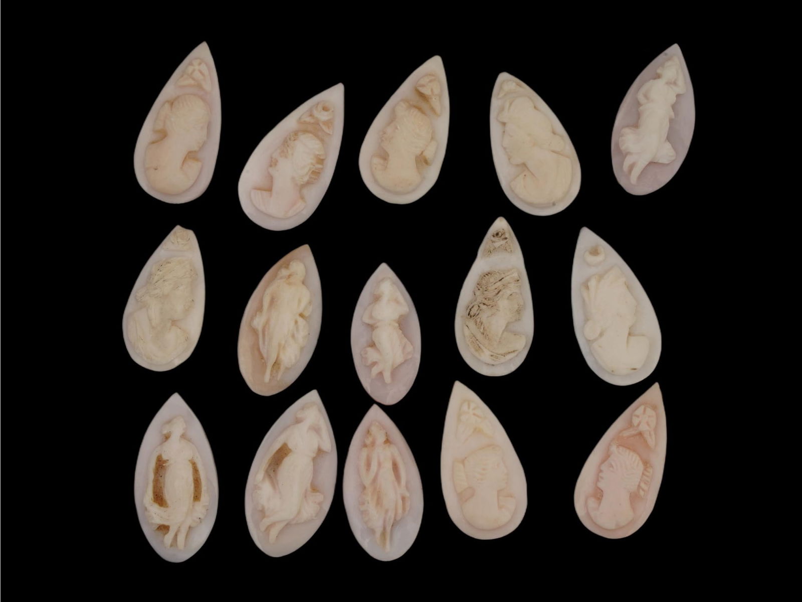 LOT OF FEMALE PORTRAIT FIGURES CARVED CORAL CAMEOS: A collection of hand carved pink Coral cameos. A total of 15 items. Each depicts a female profile bust or figure in relief in the Victorian or Neoclassical manner. The cameos are formed as small drop