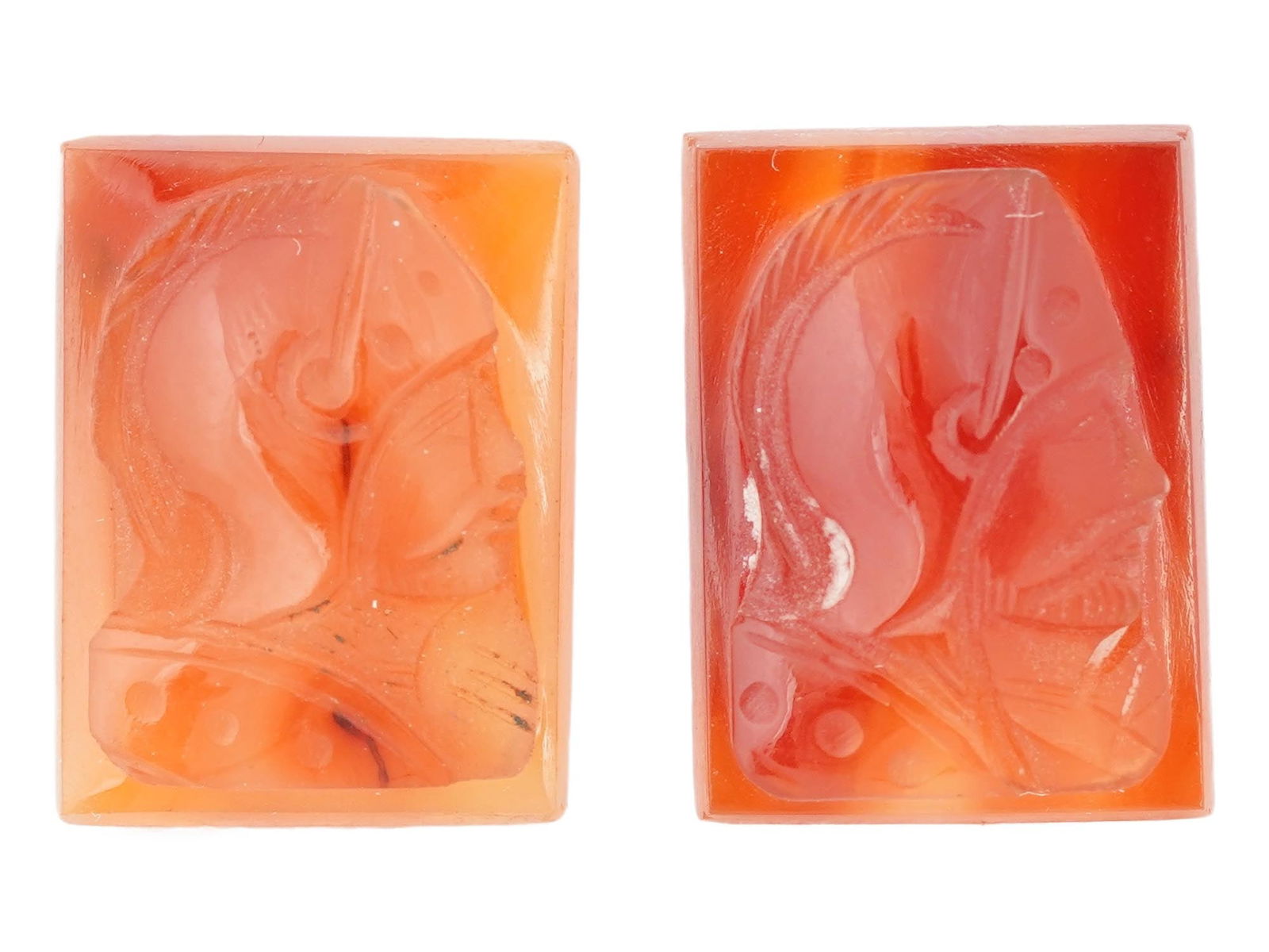 PAIR OF ANTIQUE CARNELIAN WARRIOR PROFILE CAMEOS: A pair of antique carnelian cameos with warrior portraits. Rectangular cameos made of carnelian of varying shades with a carved, almost identical image of a warrior in armor and a high helmet in right