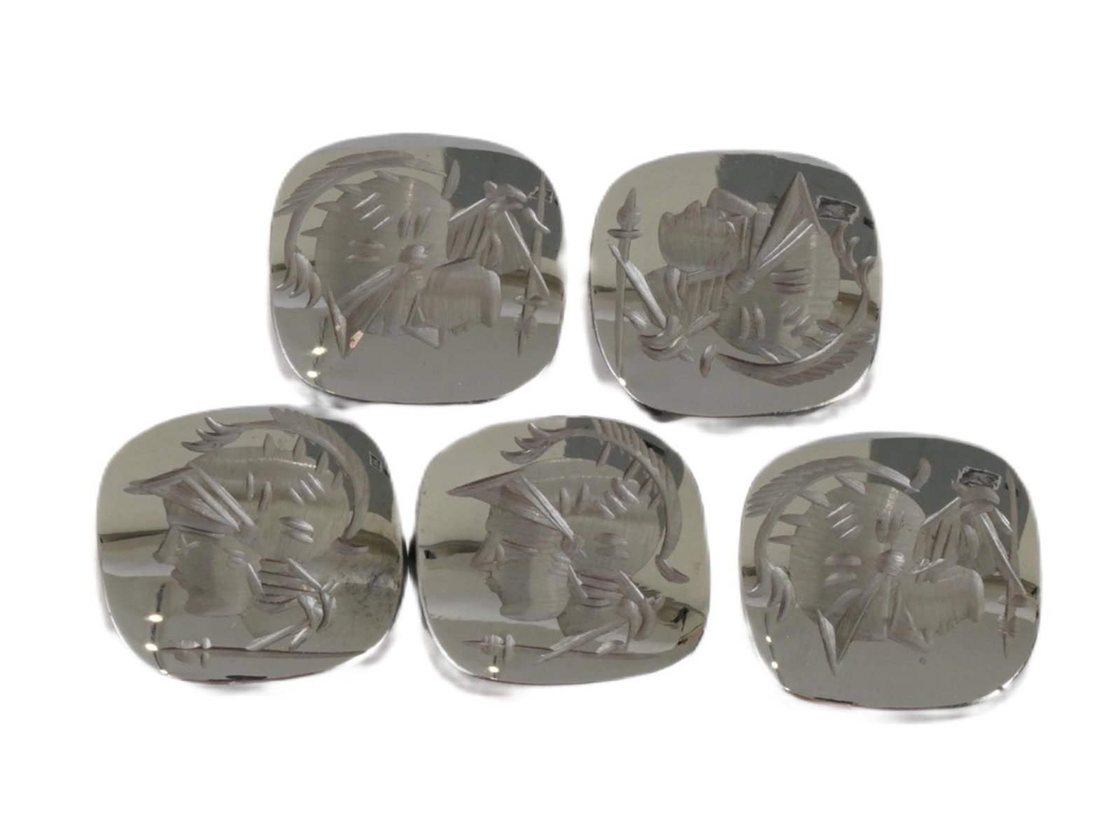 COLLECTION OF CARVED HEMATITE INTAGLIOS ROMAN SOLDIERS: A collection of five carved hematite intaglios featuring profiles of Roman soldiers, intended as vintage mens jewelry accents for rings or cufflinks. Crafted from hematite, a dark metallic stone, the