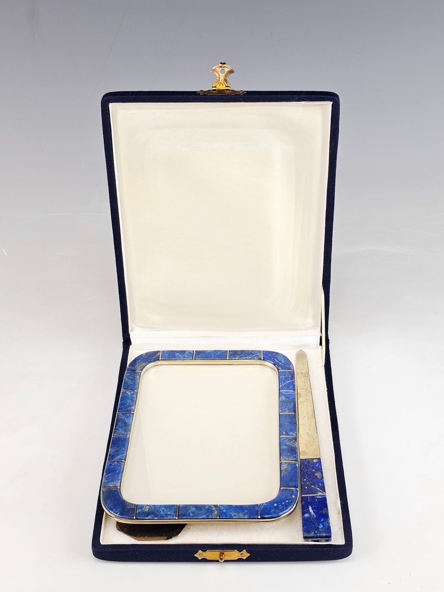 VTG LAPIS LAZULI PHOTO FRAME AND LETTER OPENER IN BOX: A vintage set consisting of a photo frame and a letter opener, adorned with lapis lazuli segments. Both items share a consistent design, featuring deep blue lapis lazuli inserts and a metal base. Unma