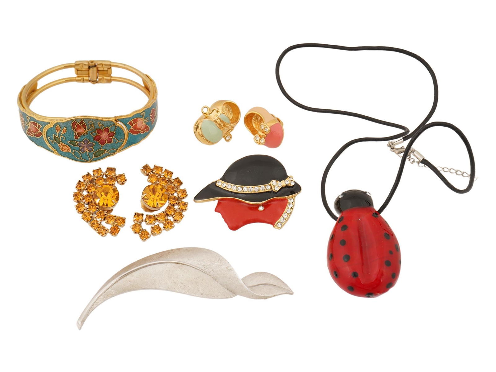 COLLECTION OF VINTAGE ENAMEL COSTUME JEWELRY: A collection of vintage costume jewelry. The lot includes enamel bangle bracelet in Asian style, rhinestone clip-on earrings, enamel brooch in the shape of the womans head, ladybug necklace, silver co