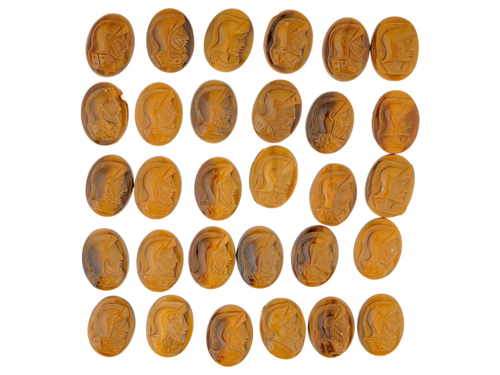 COLLECTION OF PORTRAIT CARVED TIGERS EYE STONE CAMEOS: A collection of 30 hand carved stone cameos. Each depicts a profile bust in relief, identified as Roman soldiers, warriors. Carved from natural tigers eye stone. The cameos are formed as small oval sh