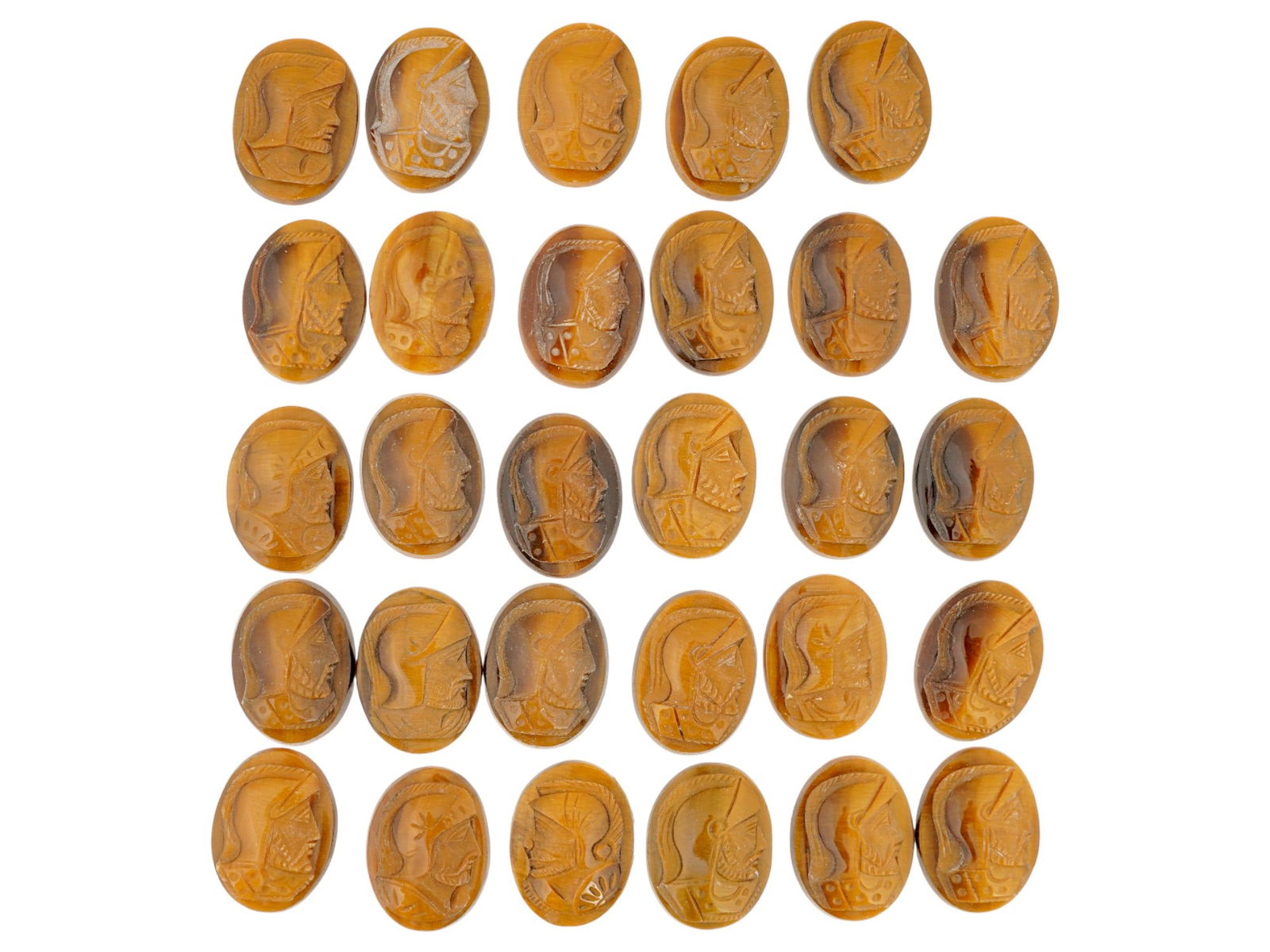 COLLECTION OF PORTRAIT CARVED TIGERS EYE CAMEOS: A collection of hand carved tigers eye cameos. A total of 29 items. Each piece features a knight profile portrait rendered in high relief. Oval shape. Collectible Jewelry And Glyptic Art, Sculpture.