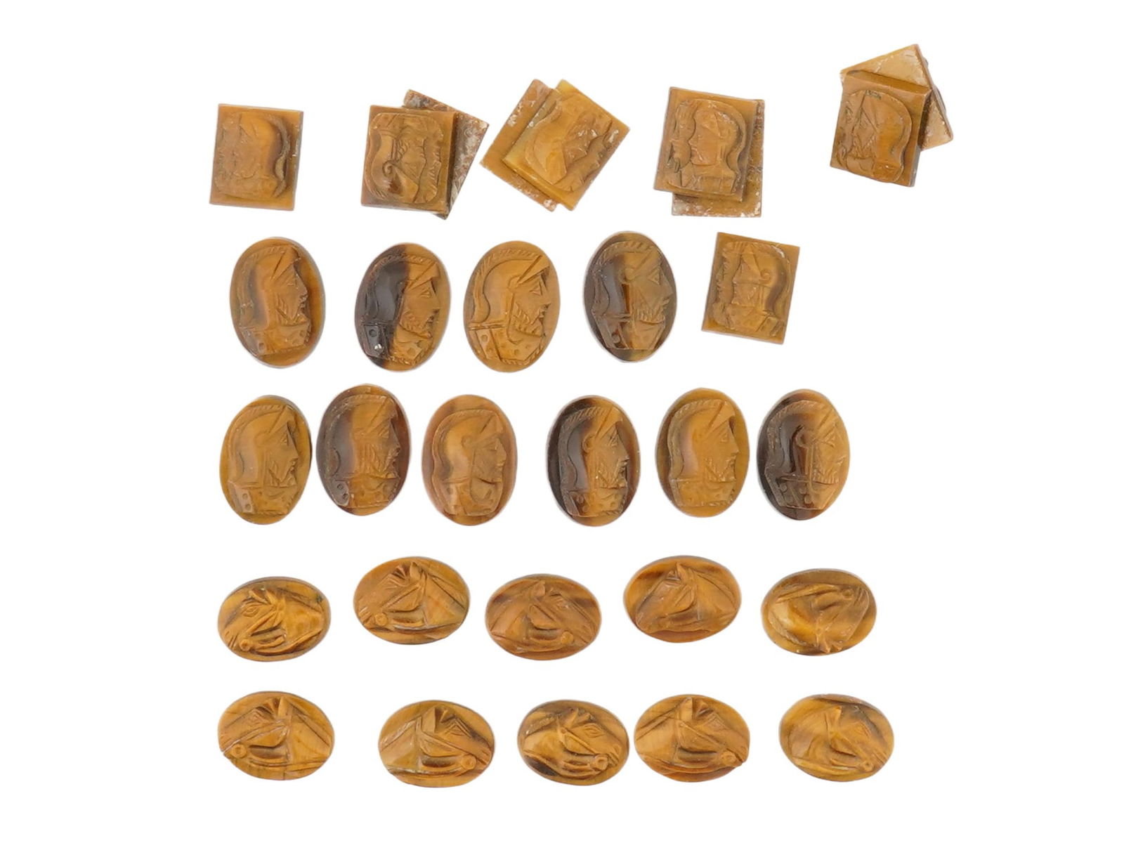 COLLECTION OF PORTRAIT CARVED TIGERS EYE STONE CAMEOS: A collection of 30 hand carved stone cameos. Each depicts a profile bust in relief, identified as Roman soldiers, warriors and heads of horses. Carved from natural tigers eye stone. The cameos are for
