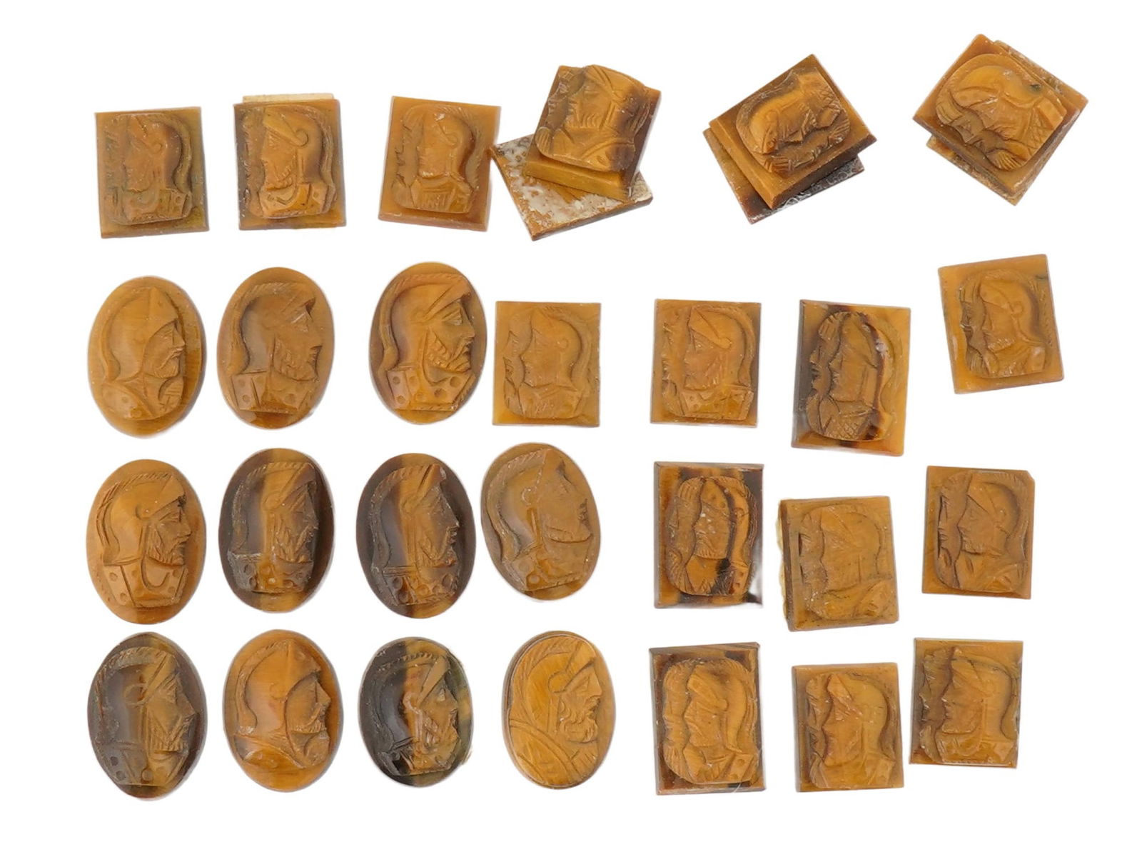 COLLECTION OF PORTRAIT CARVED TIGERS EYE CAMEOS: A collection of hand carved tigers eye cameos. A total of 30 items. Each piece features a knight profile portrait rendered in high relief. Square and oval shape. Collectible Jewelry And Glyptic Art, S