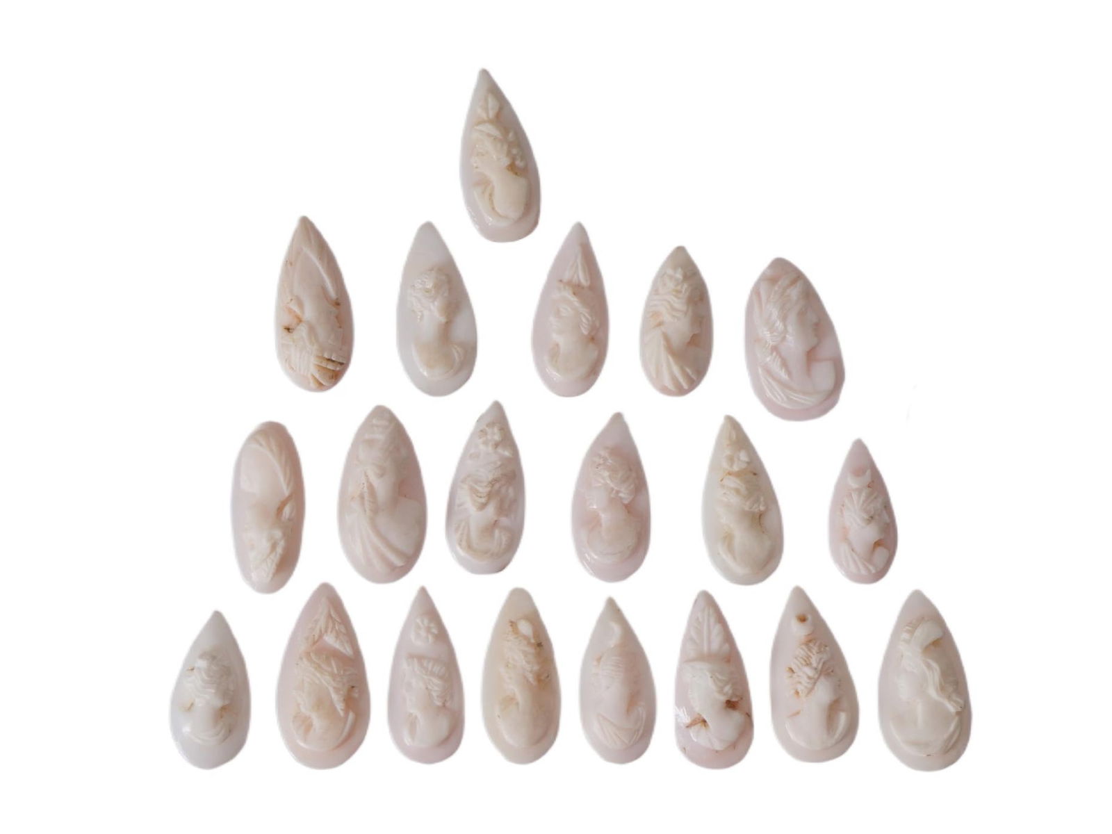 COLLECTION OF FEMALE PORTRAIT CARVED CORAL CAMEOS: A collection of hand carved pink coral cameos. A total of 20 items. Each piece depicts a female profile portrait rendered in high relief. Drop shape. Collectible Jewelry And Glyptic Art, Sculpture.