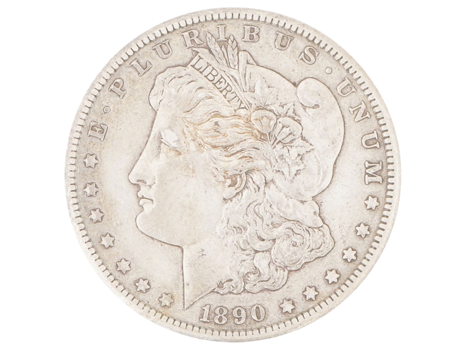 ANTIQUE 1890 AMERICAN CARSON CITY MORGAN SILVER DOLLAR: An antique 1890 American Morgan silver dollar coin. Minted in Carson City. Named after its designer, George T. Morgan, this coin is one of the most iconic pieces of American coinage. The obverse featu