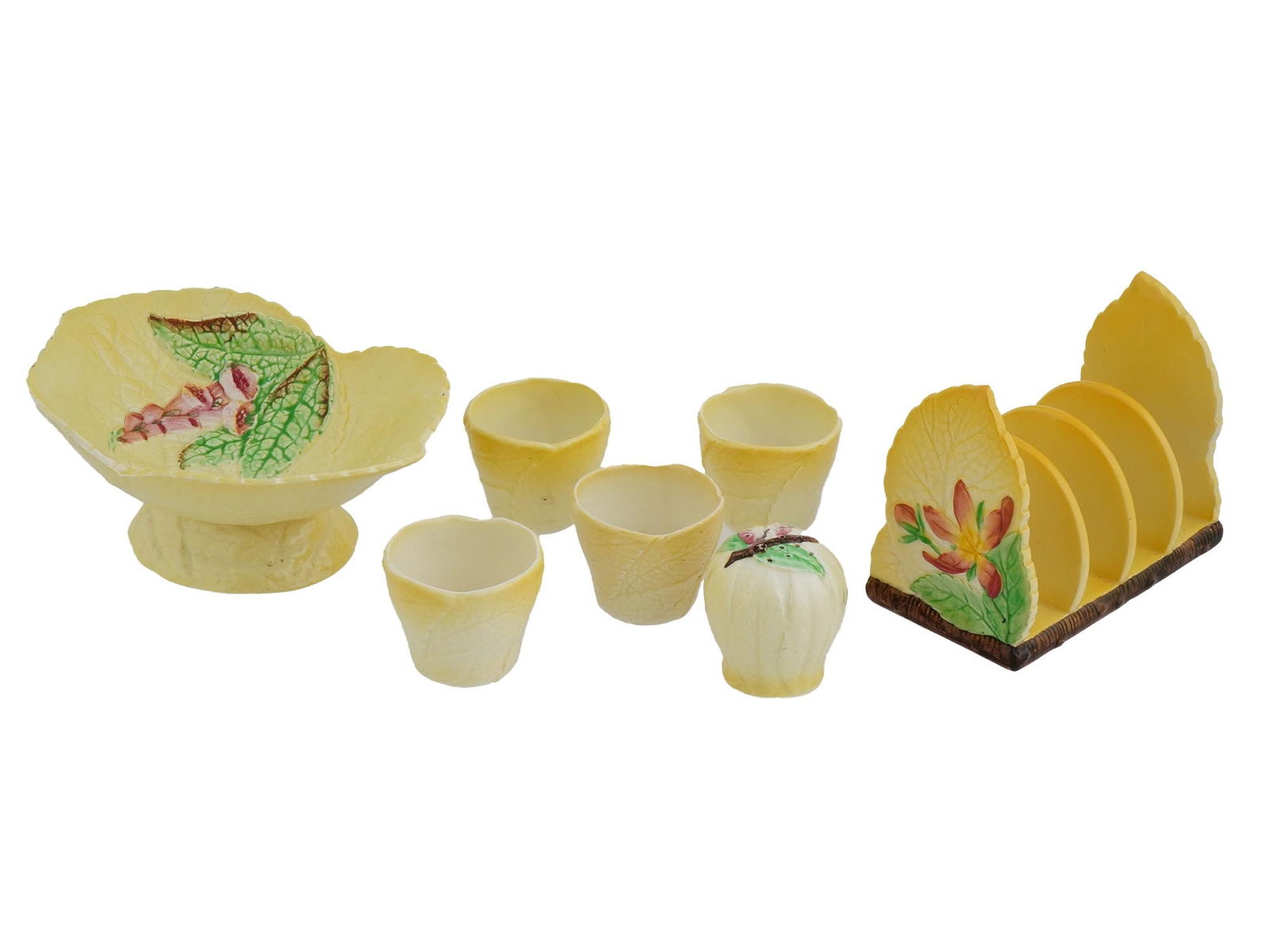 VINTAGE CARLTON WARE WILD ROSE CERAMIC SET: A vintage English Carlton Ware ceramic set from the Wild Rose Collection, consisting of a toast bin, four poached egg holders, a salt shaker, and a small pedestal, all adorned with a pale yellow finis