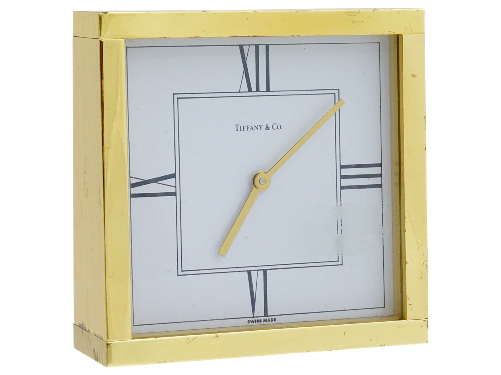 VINTAGE TIFFANY AND CO BRASS TABLE CLOCK: A vintage table clock by Tiffany and Co. Square gilt brass case. White dial with Roman numerals, marked Tiffany and Co., Swiss Made. Collectible Clocks And Watches, Home Decor. THIS LOT IS ELIG