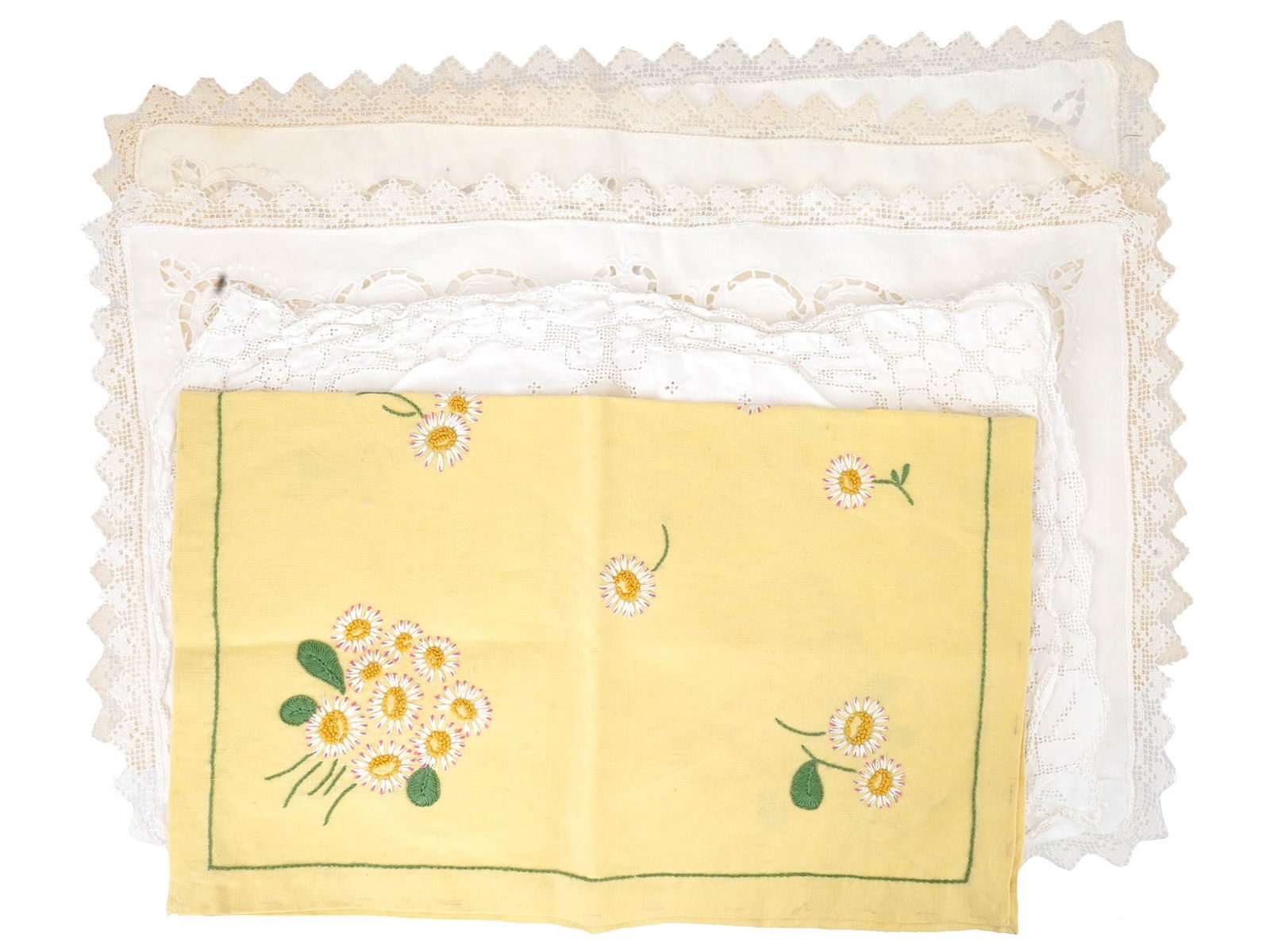 SET OF ASSORTED ANTIQUE AND VINTAGE TRAY DOILIES: A set of assorted antique and vintage tray doilies presents a variety of styles and materials, including delicate lace, detailed cutwork, and a yellow linen piece embellished with daisy embroidery and