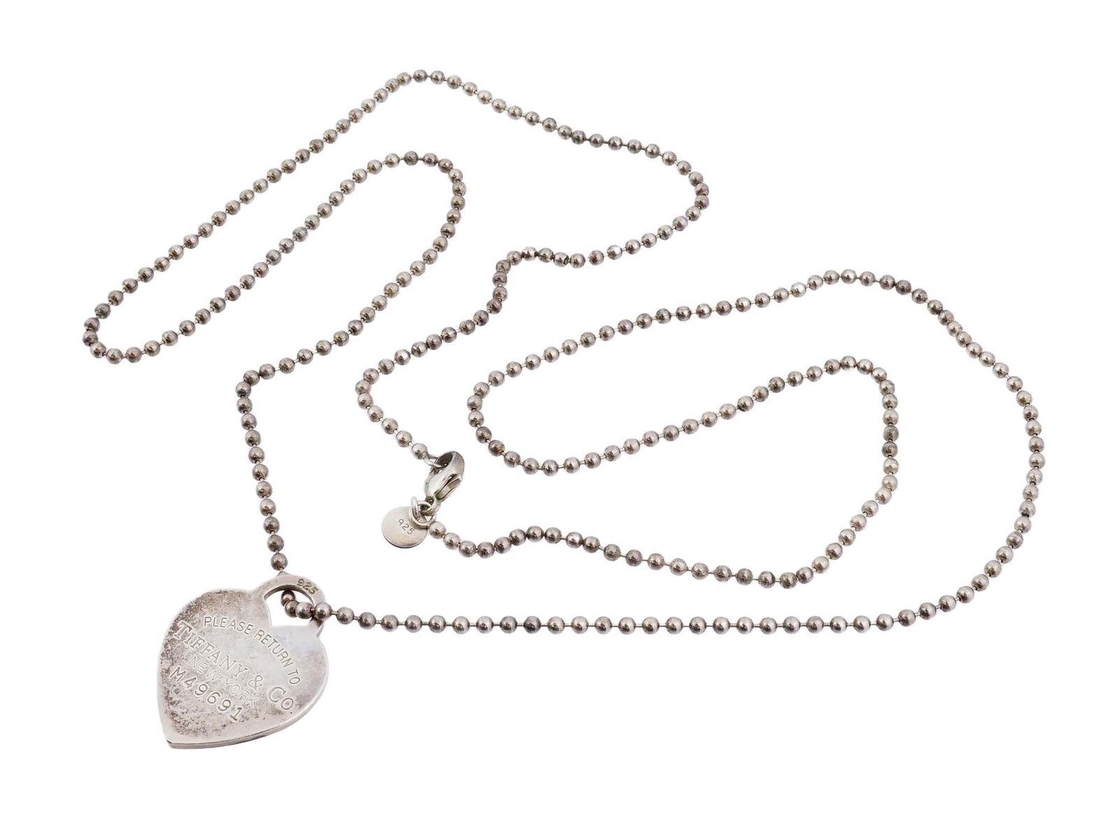 VTG TIFFANY STERLING SILVER HEART TAG PENDANT NECKLACE: A vintage Tiffany and Co. sterling silver heart tag pendant necklace, crafted in 925 silver and featuring the iconic Please Return to Tiffany and Co. New York engraved design. The heart-shaped tag is
