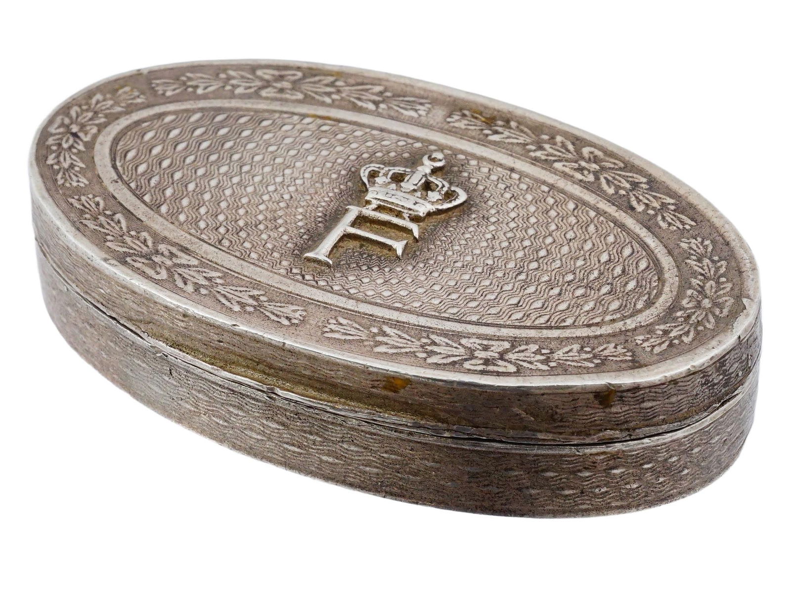 KING FAROUK EGYPTIAN FRENCH AUCOC SILVER PILL BOX: A silver pill box features the royal monogram of King Farouk I, was a King of Egypt, reigned 1936 to 1952. The oval box is crafted with a detailed guilloche pattern on the lid and sides, bordered by a