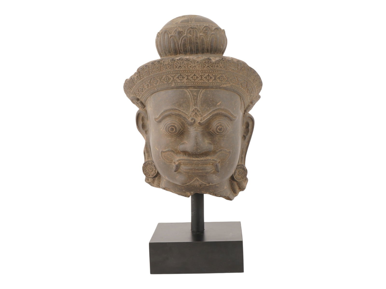 KHMER ART BUDDHIST CARVED STONE HEAD OF YAKSHA: A hand carved stone head of a Yaksha, a guardian deity in Khmer art. This sculpture is made in the Angkor Wat or Banteay Srei style, which were characteristic of the Khmer Empire from approximately th
