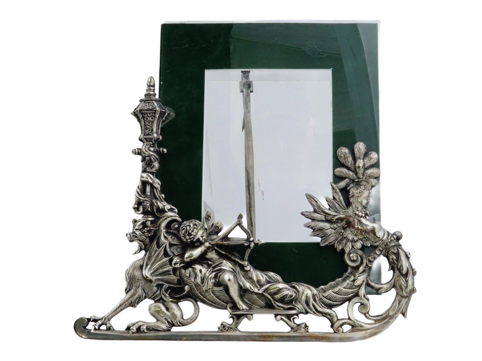 NEOCLASSICAL MANNER CHERUB DESIGN IRON PICTURE FRAME: A vintage Neoclassical manner iron picture frame. The frame is decorated with a complex figural composition. The main element is a putti cherub shooting a bow. He sits in a decorative chariot or boat