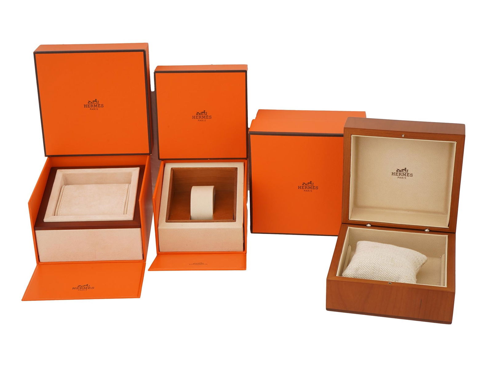GROUP OF THREE HERMES ORANGE SQUARE BOXES: A group of three Hermes square boxes in the iconic orange color. Each box is a testament to the elegance and luxury associated with this renowned fashion house. The Hermes boxes are emblematic of the