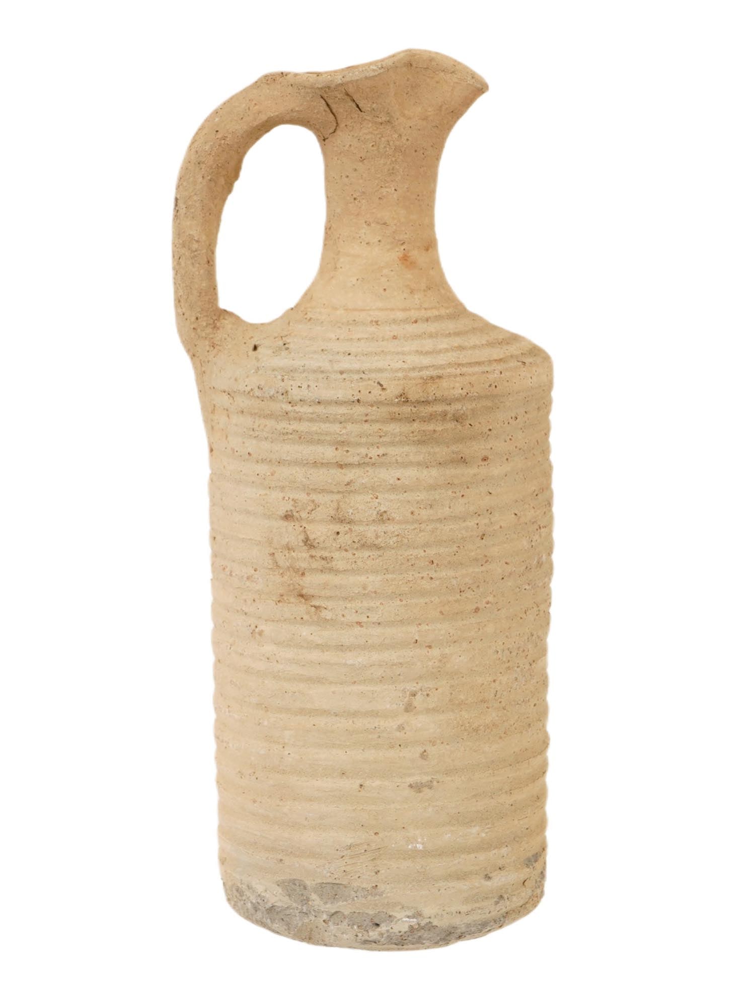ANCIENT BYZANTINE DUCK SPOUT CLAY PITCHER 400 TO 600 AD: An ancient Byzantine Empire pottery pitcher, dating from 400 to 600 AD. The pitcher has a prolonged form with a handle connecting the neck and body. The body of the ware is adorned with a ribbed desig