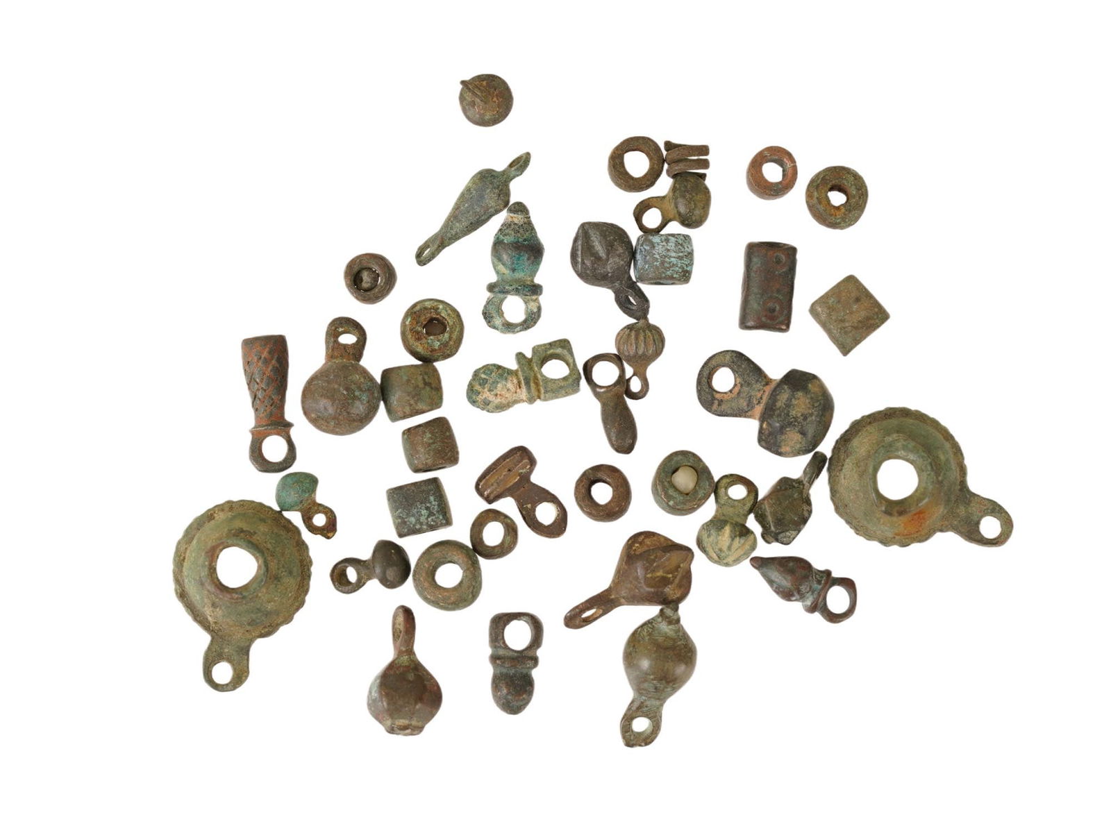 GROUP OF ANCIENT BRONZE PENDANTS THE HOLY LAND REGION: A group of ancient bronze pendants from the Holy Land region, dating approximately 1000 BC to 100 AD, featuring a varied assortment of cast forms used as personal adornment or amuletic objects. Ancien