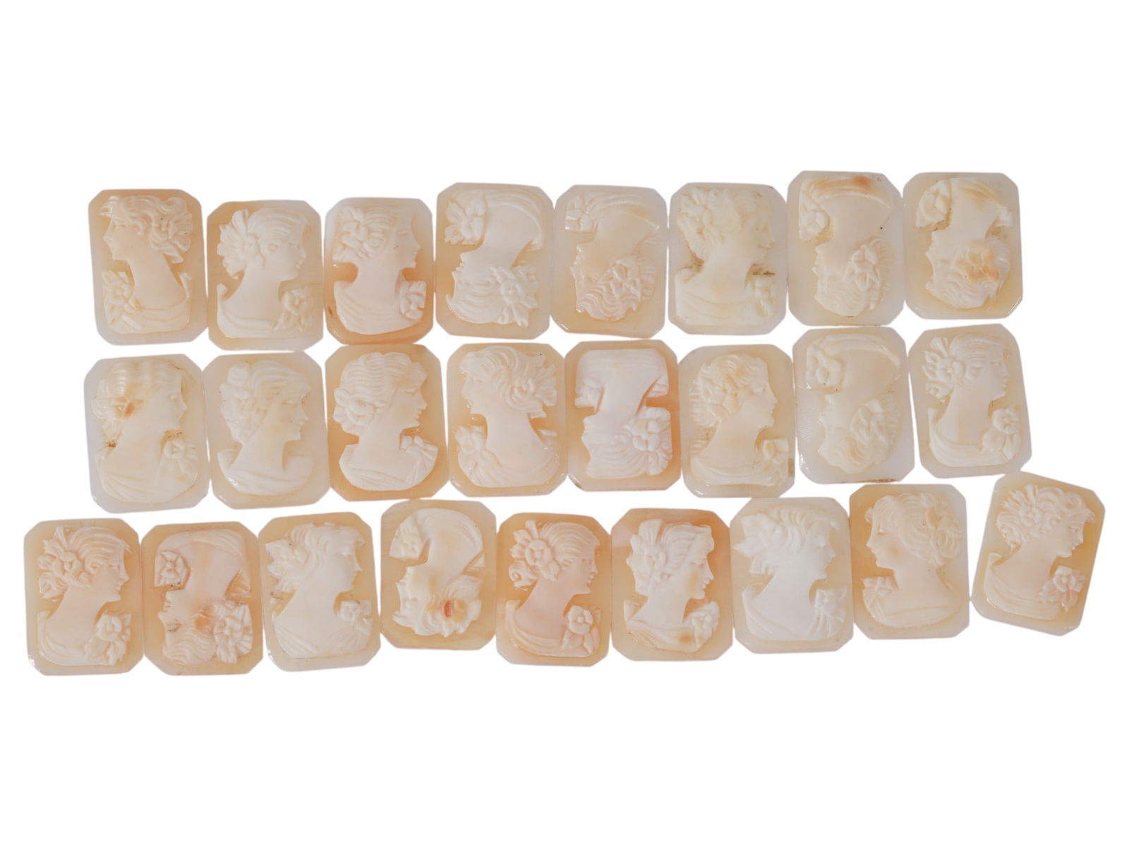 COLLECTION OF CARVED FEMALE PORTRAIT SHELL CAMEOS: A collection of hand carved shell cameos. A total of 25 items. Each piece depicts a female profile portrait rendered in high relief in the Victorian manner. Each cameo is fashioned in a distinctive oc