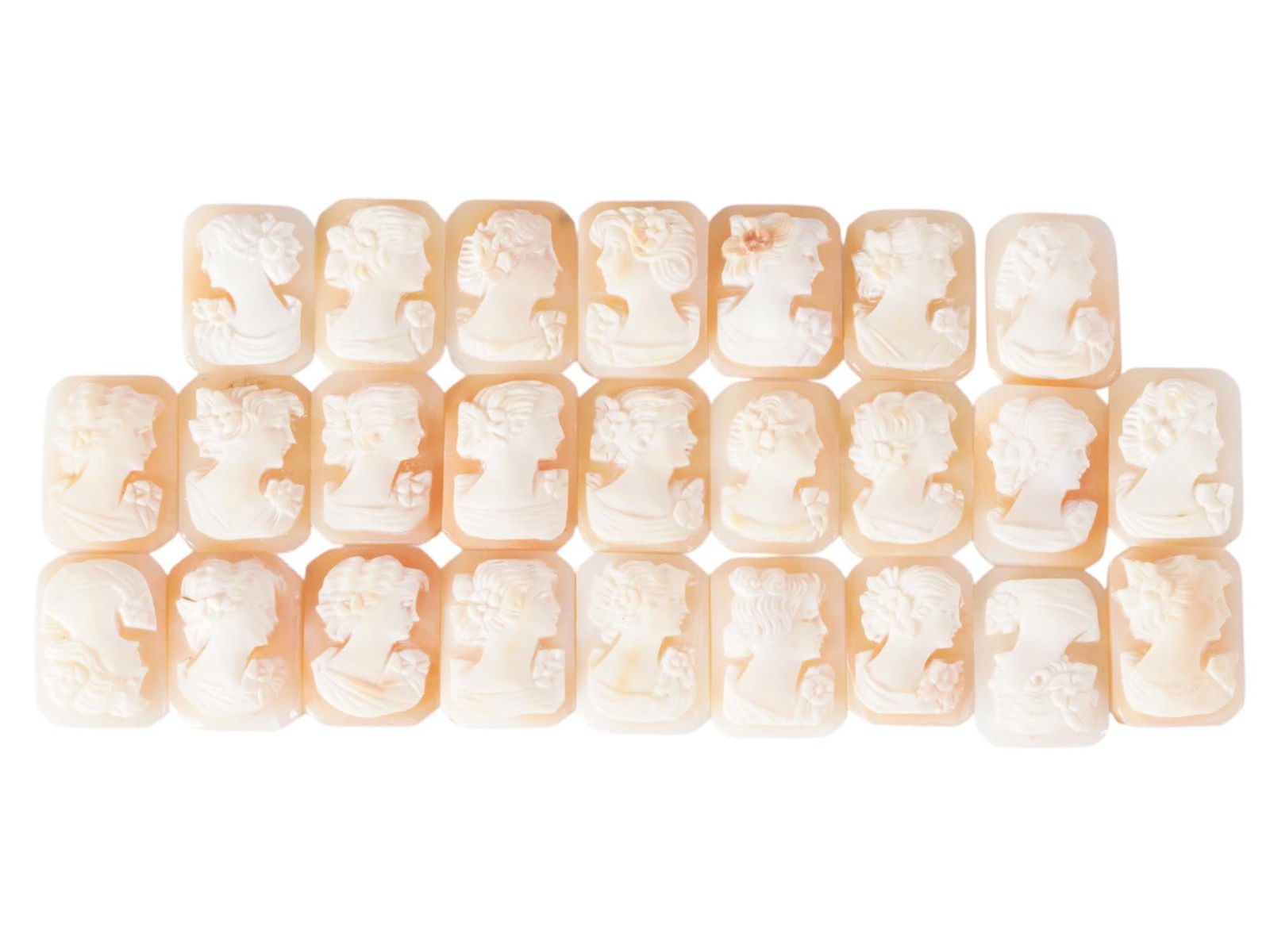 COLLECTION OF CARVED FEMALE PORTRAIT SHELL CAMEOS: A collection of hand carved shell cameos. A total of 25 items. Each piece depicts a female profile portrait rendered in high relief in the Victorian manner. Each cameo is fashioned in a distinctive oc