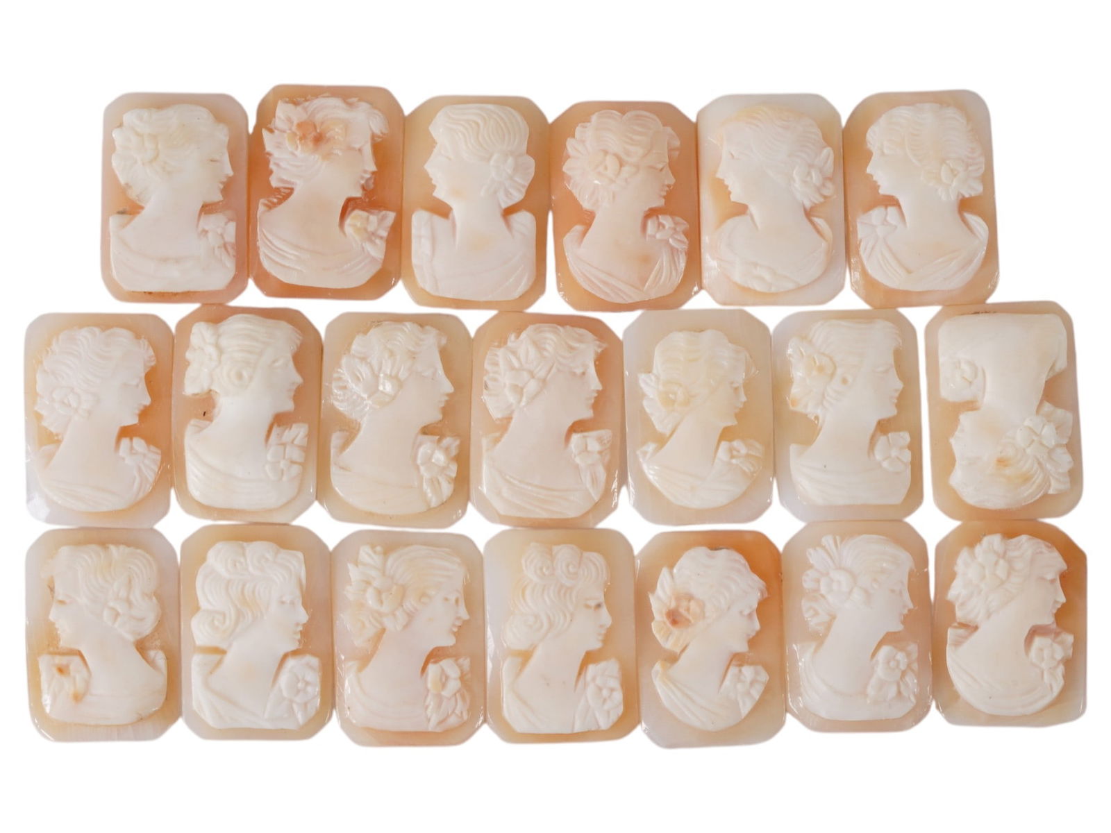 COLLECTION OF CARVED FEMALE PORTRAIT SHELL CAMEOS: A collection of hand carved shell cameos. A total of 20 items. Each piece depicts a female profile portrait rendered in high relief in the Victorian manner. Each cameo is fashioned in a distinctive oc