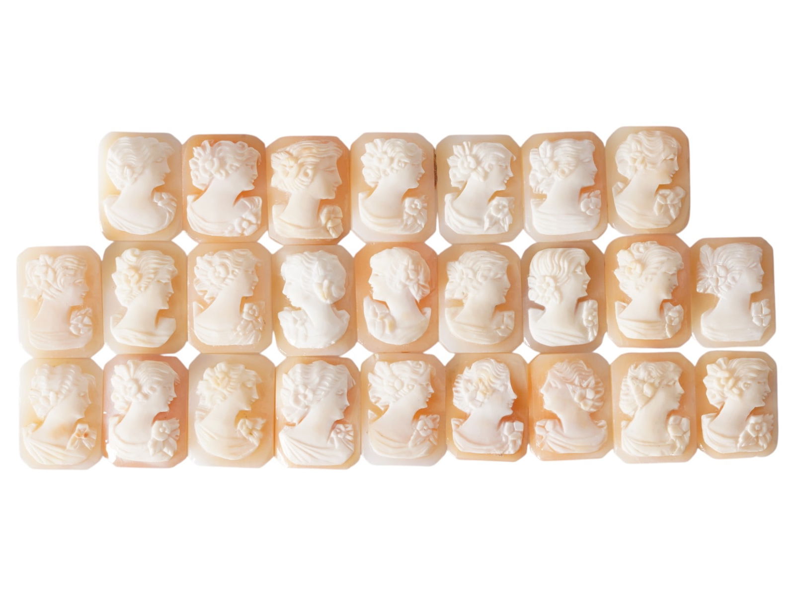 COLLECTION OF CARVED FEMALE PORTRAIT SHELL CAMEOS: A collection of hand carved shell cameos. A total of 25 items. Each piece depicts a female profile portrait rendered in high relief in the Victorian manner. Each cameo is fashioned in a distinctive oc