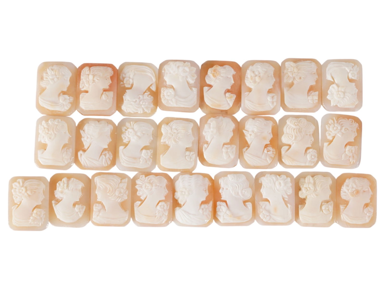COLLECTION OF CARVED FEMALE PORTRAIT SHELL CAMEOS: A collection of hand carved shell cameos. A total of 25 items. Each piece depicts a female profile portrait rendered in high relief in the Victorian manner. Each cameo is fashioned in a distinctive oc