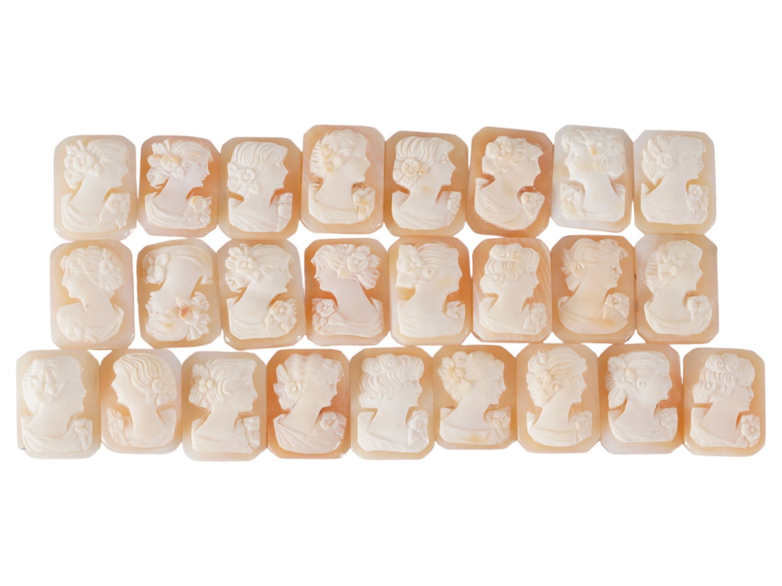 COLLECTION OF CARVED SHELL CAMEOS WITH FEMALE PORTRAITS: A collection of 25 carved shell cameos featuring high-relief female portraits, executed in a traditional classical style associated with Victorian-era jewelry. The loose unmounted pieces display detai