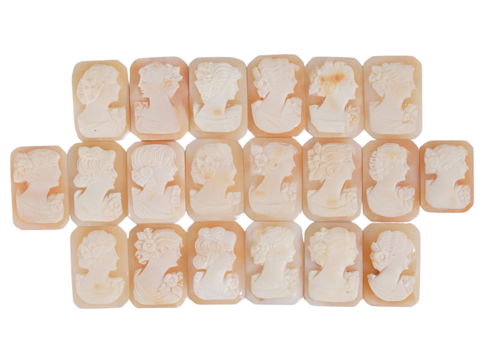 COLLECTION OF CARVED SHELL CAMEOS WITH FEMALE PORTRAITS: A collection of 20 carved shell cameos featuring high-relief female portraits, executed in a traditional classical style associated with Victorian-era jewelry. The loose unmounted pieces display detai