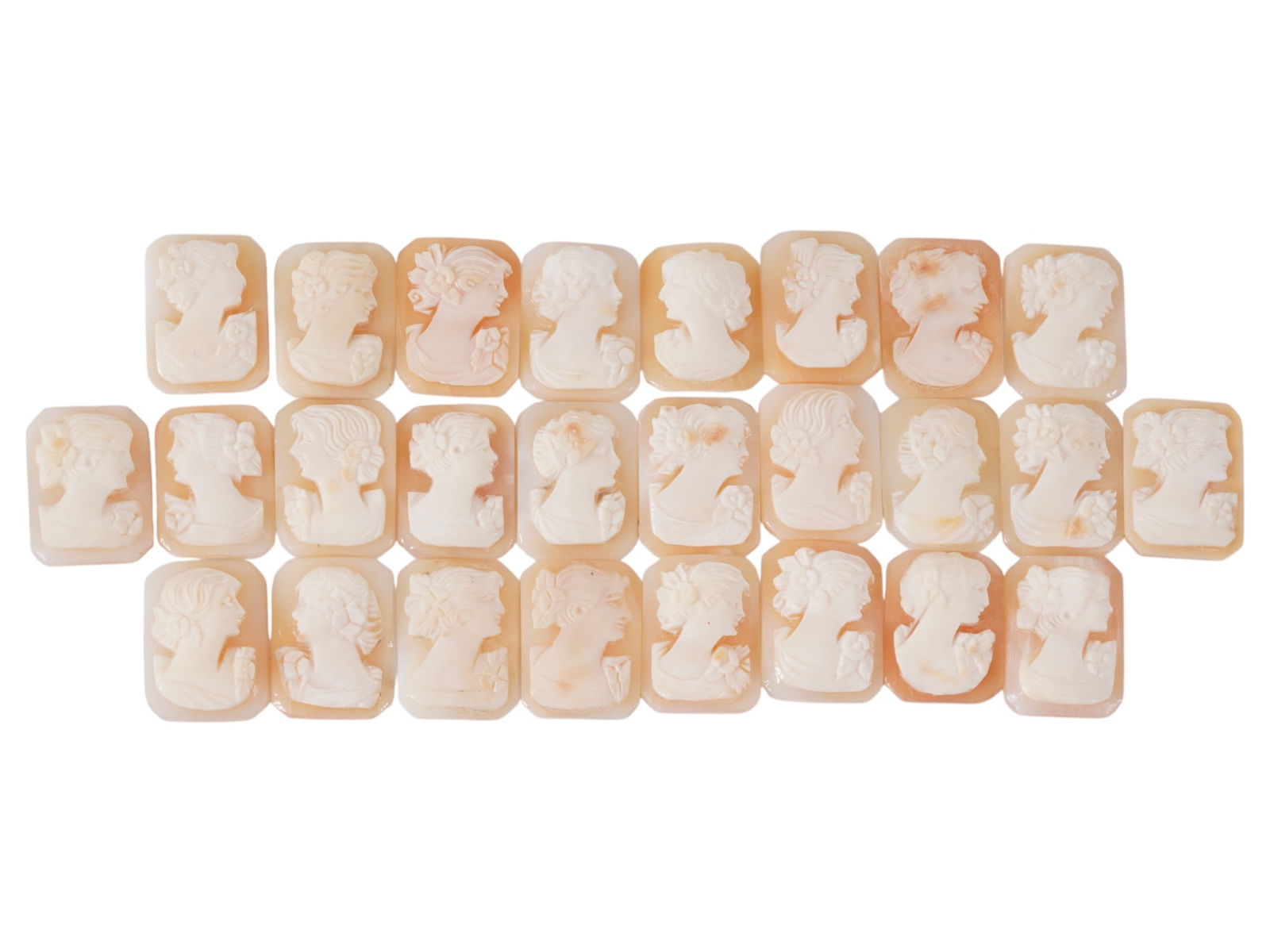 COLLECTION OF FEMALE PORTRAIT CARVED SHELL CAMEOS: A collection of hand carved shell cameos. A total of 26 items. Each piece depicts a female profile portrait rendered in high relief in the Victorian manner. Each cameo is fashioned in a distinctive oc