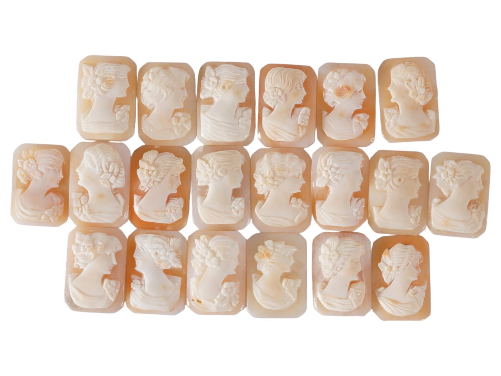 COLLECTION OF FEMALE PORTRAIT CARVED SHELL CAMEOS: A collection of hand carved shell cameos. A total of 20 items. Each piece depicts a female profile portrait rendered in high relief in the Victorian manner. Each cameo is fashioned in a distinctive oc