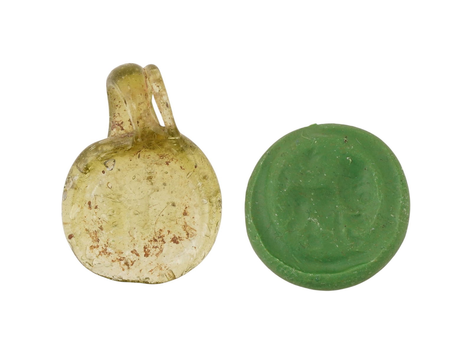 ANCIENT ROMAN GLASS PENDANT ENGRAVED WITH A LION: An ancient Roman glass pendant dating to circa 100 to 300 AD, formed and engraved with a lion beneath a star. The pendant reflects the widespread popularity of zodiac symbolism in the Roman world, whe