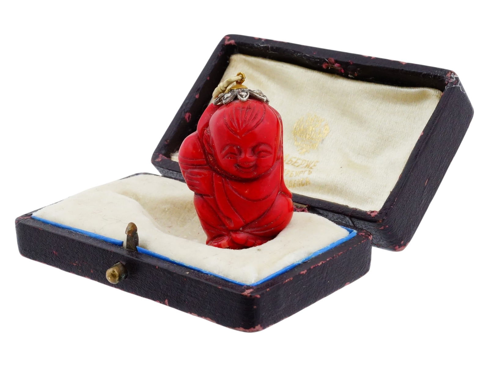 CARVED RED CORAL SILVER PENDANT BUDDHA WITH DIAMONDS: A carved red coral pendant depicting Buddha in the joyful Happy Putai form, symbolizing prosperity, contentment, and good fortune. The figure is surmounted by a silver floral-style cap set with small