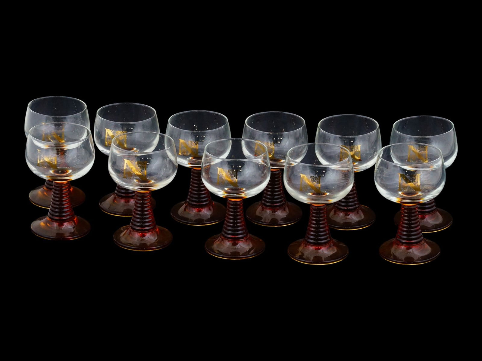 FRENCH ROEMER BEEHIVE STERM DESIGN WINE GLASSES SET: A vintage French Roemer wine glasses set with a distinctive amber beehive shaped stem. The set includes eleven glasses. Each ware is adorned with a ribbed amber or honey colored stem, often called a