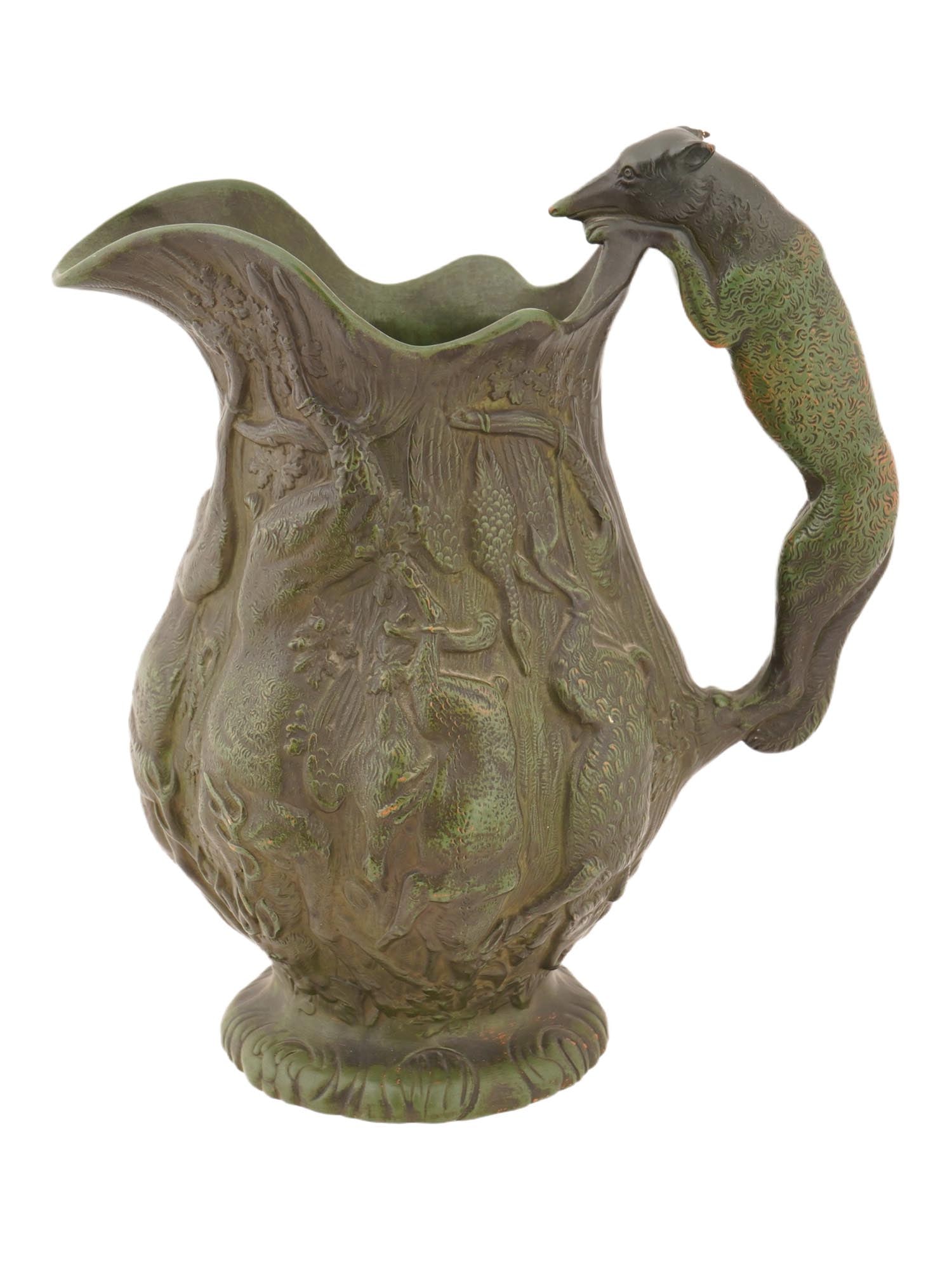 ANTIQUE EUROPEAN CERAMIC JUG W HUNTING SCENES: An antique European ceramic figural jug with hunting scenes. Presumably of English origin. The jug features a wavy top rim and a long, elongated spout. The entire surface is decorated with relief imag