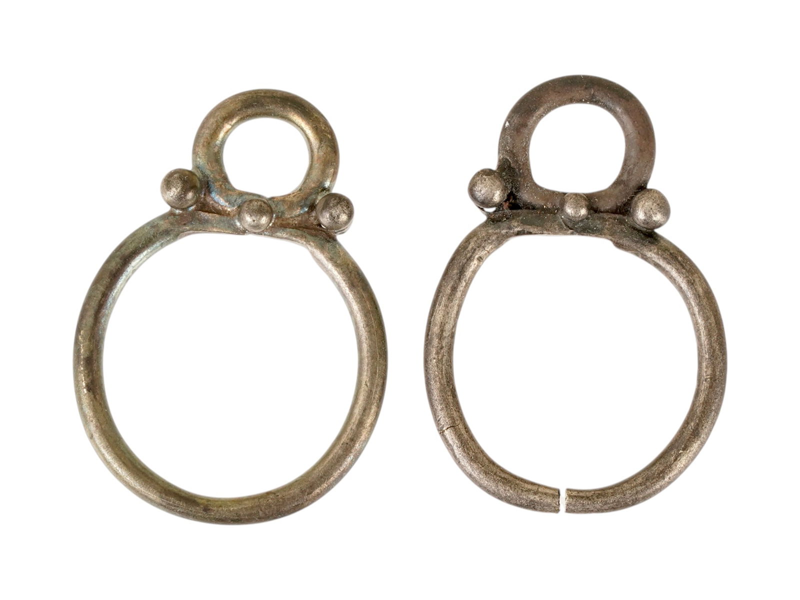PAIR ANCIENT GRECO ROMAN SILVER PENDANTS EARRINGS: A pair of ancient Greco Roman silver idol pendants, possibly earrings. Circa 200 BC to 100 AD. The items are the same and feature a double ring and three bead motifs. Ancient Artifacts And Jewelry Col