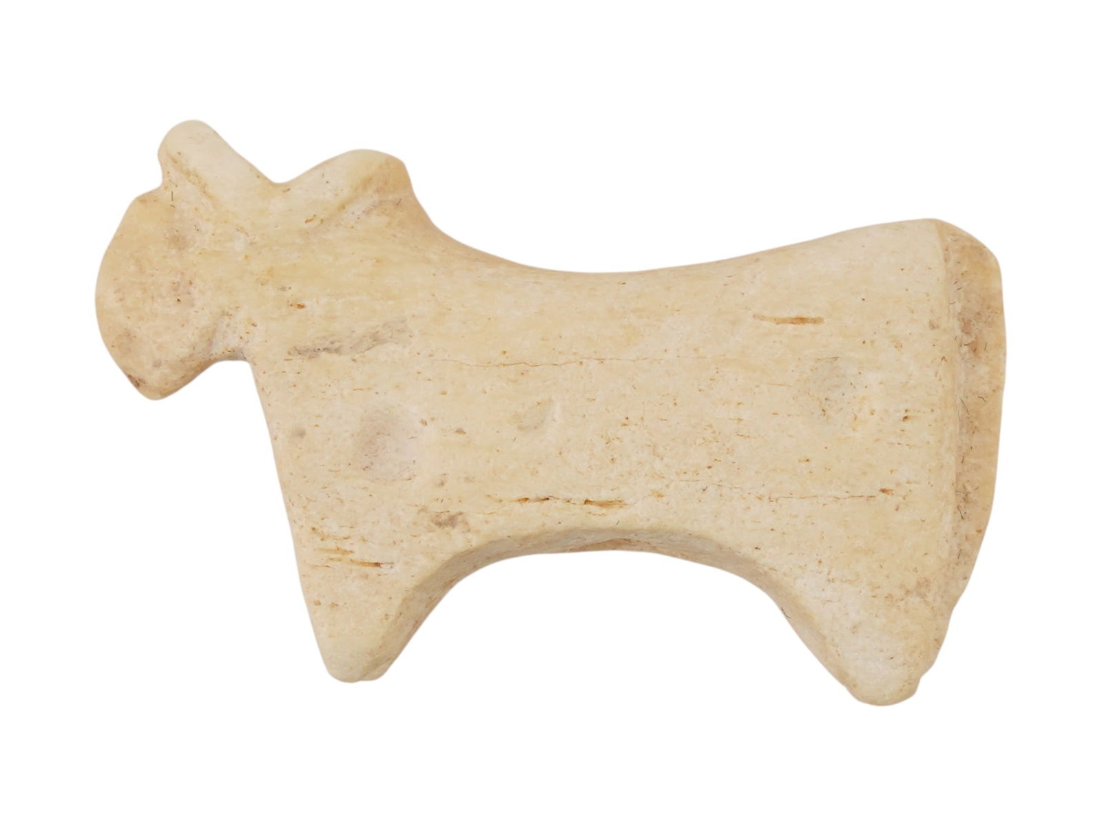ANCIENT GREEK SOFT STONE BULL PENDANT CA 600 TO 400 BC: An ancient Greek bull pendant carved of soft stone, dating to circa 600 to 400 BC. The pendant features a highly stylized, schematic representation of a bull with short, tapered legs and distinct horn