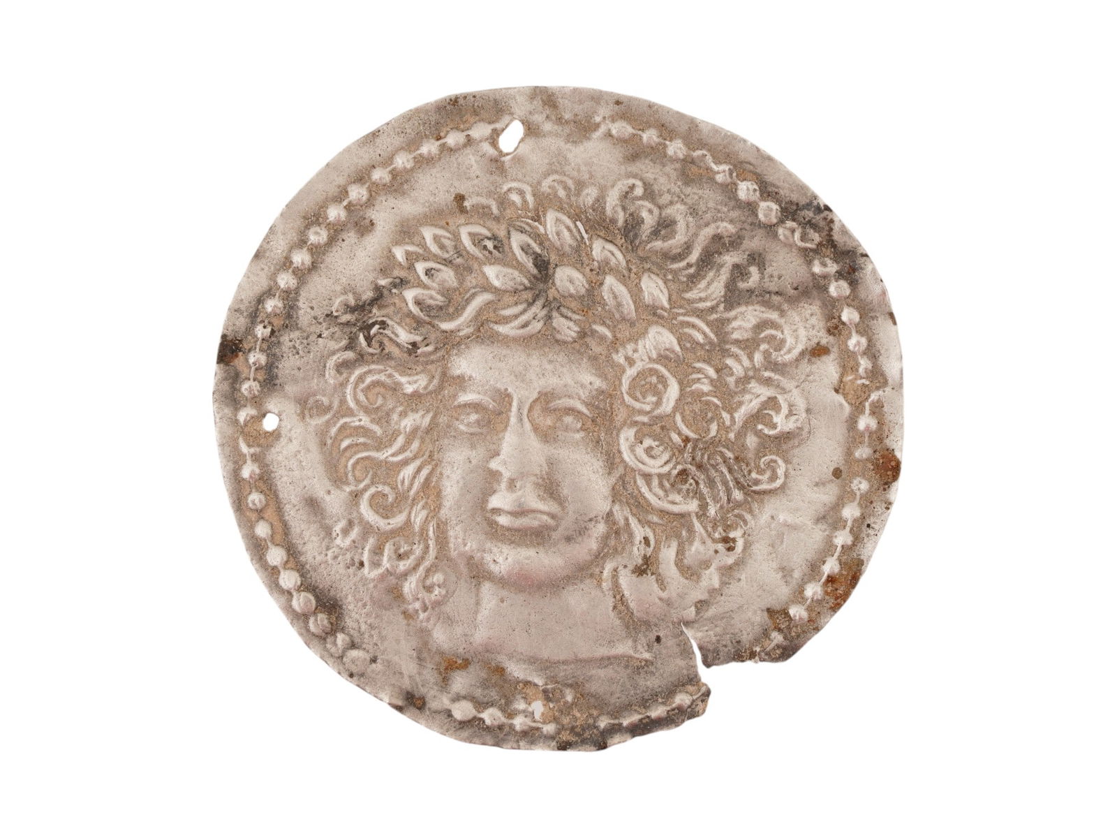 ANCIENT GRECO ROMAN SILVER PLAQUE WITH IMAGE OF MEDUSA: An ancient Greco-Roman silver plaque depicting Medusa, dating circa 200 BC to 100 AD. Presents the iconic head of Medusa with stylized serpentine hair and intense frontal gaze, an image widely employe