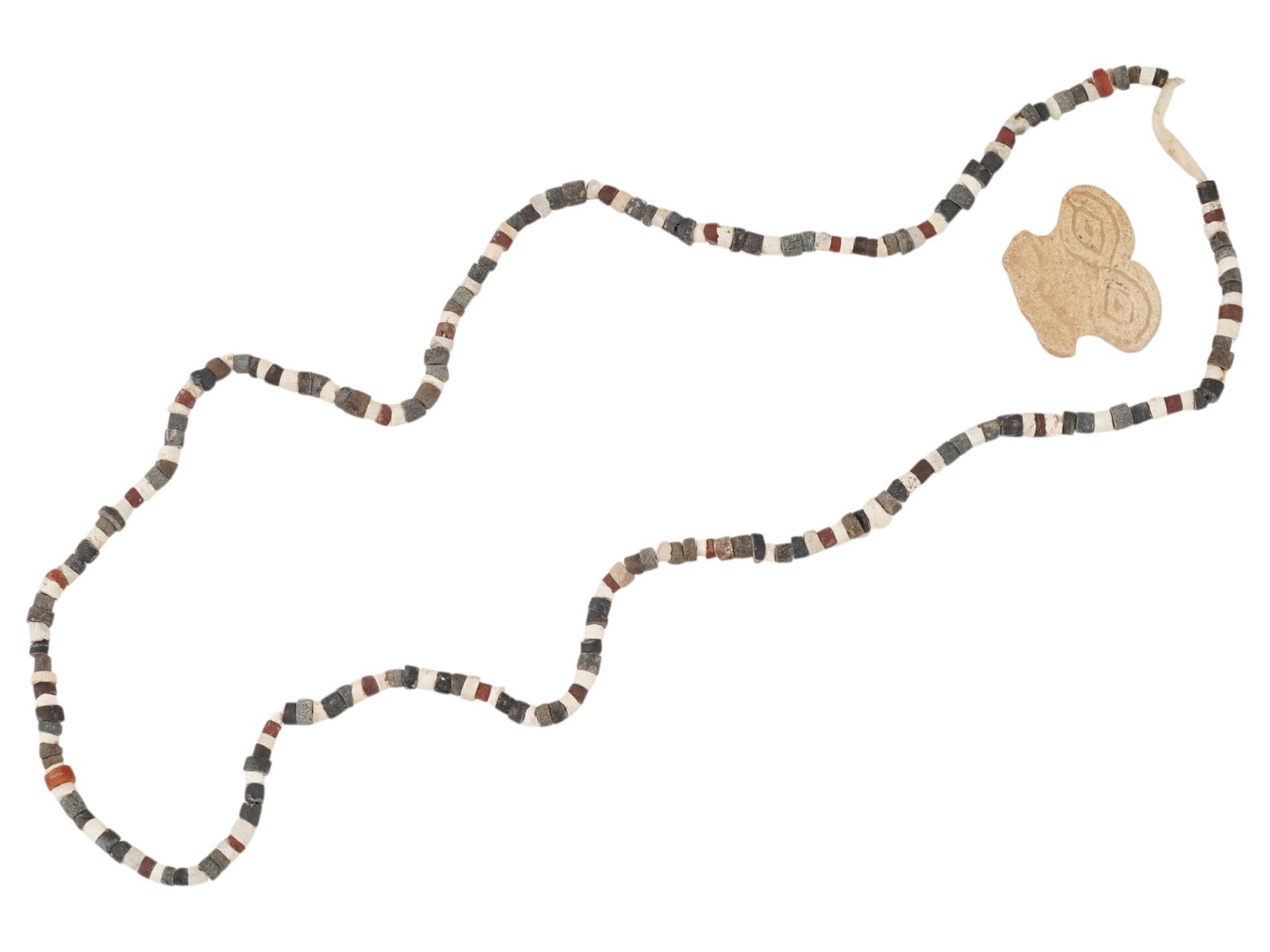 ANCIENT NEAR EASTERN EYE IDOL STEATITE BEAD NECKLACE: An ancient Near Eastern necklace crafted from multicolored Steatite stone beads. The necklace is adorned with a carved stone eye idol pendant, engraved with ornaments. Circa: 2nd Millennium BC. Ancien