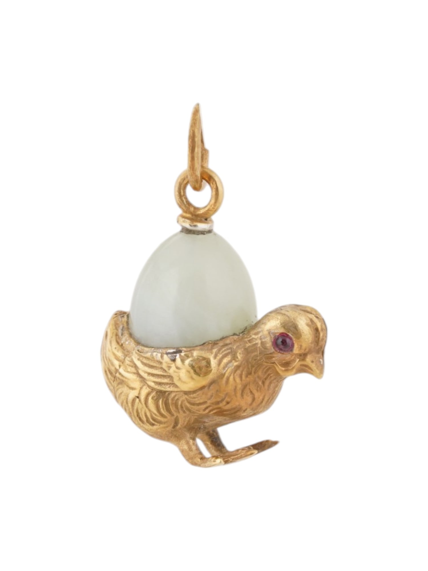 RUSSIAN GILT SILVER BOWENITE CHICKEN EASTER EGG PENDANT: A Russian gilt silver Easter egg pendant manufactured in a carved bowenite stone and mounted to a standing chicken figurine. The eyes of the chicken are set with ruby stones. Hallmarked to the suspens