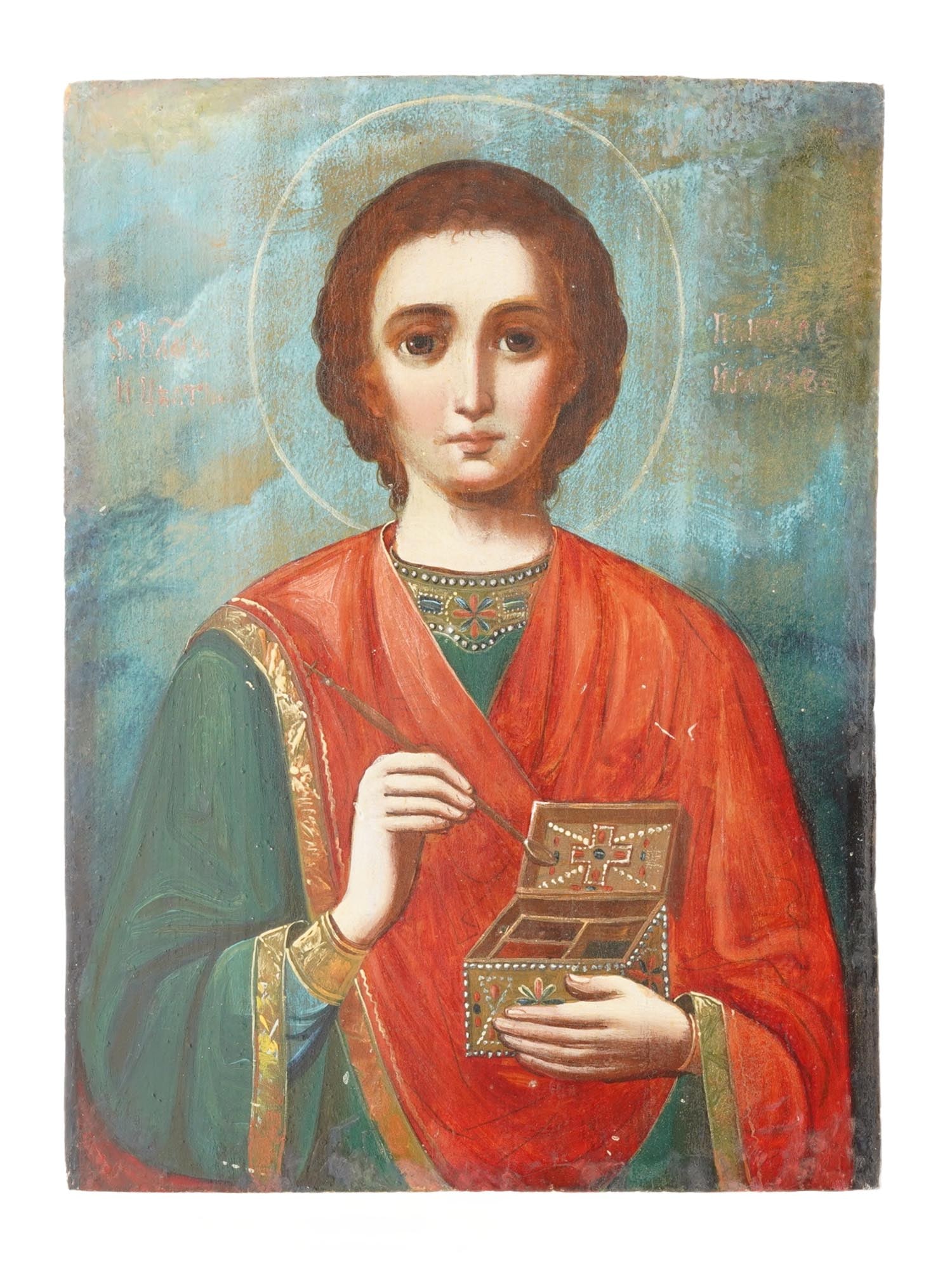 ANTIQUE RUSSIAN ORTHODOX ICON OF SAINT PANTELEIMON: An antique Russian Orthodox icon depicting Saint Panteleimon, venerated as a great martyr and unmercenary healer in Orthodox Christianity. Inscriptions in Church Slavonic identify the saint, and he is