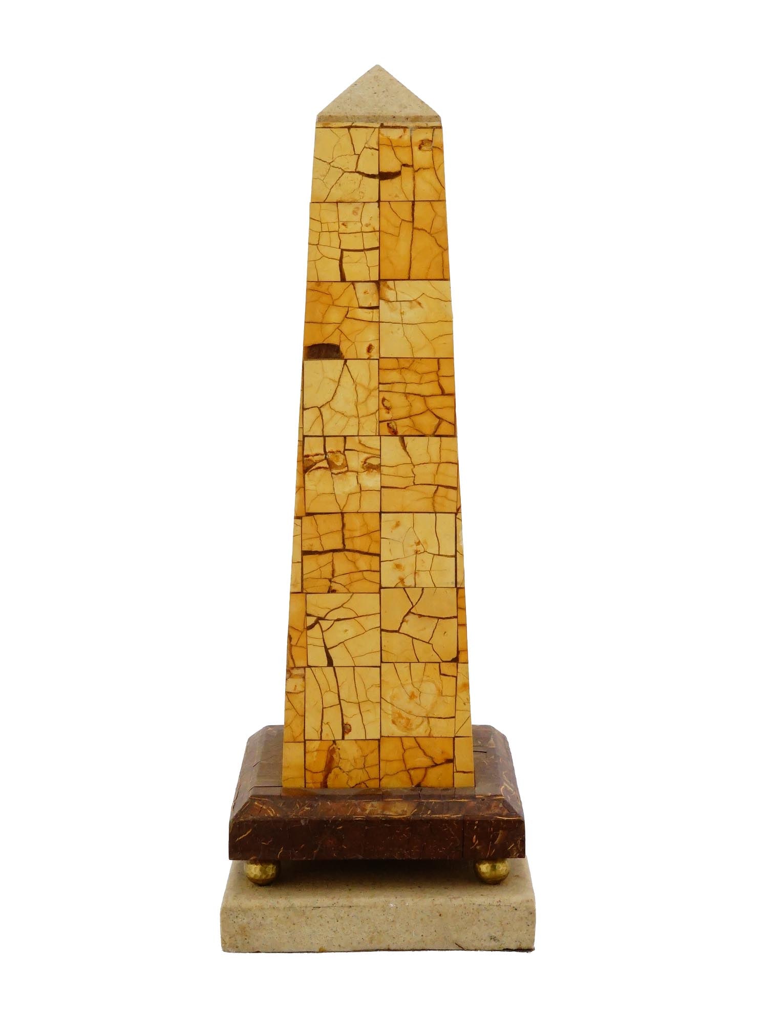 VINTAGE OBELISK WITH COCONUT SHELL INLAY ON BRASS STAND: A vintage decorative obelisk featuring a coconut shell inlay, exemplifying late 20th-century artisanal decorative design. The surface is composed of hand-cut pieces of natural coconut shell arranged i