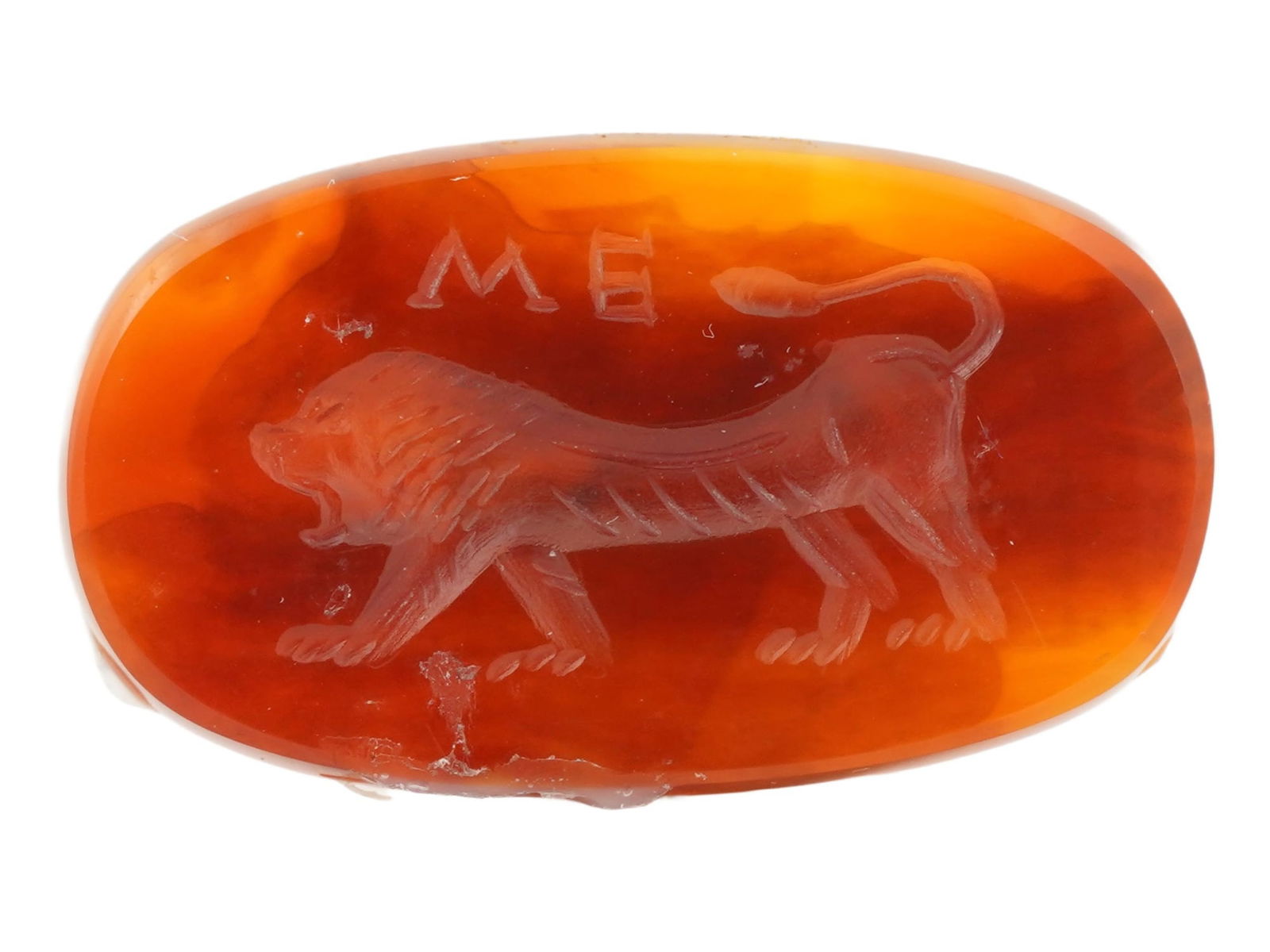 ROMAN MANNER HAND CARVED CARNELIAN STONE INTAGLIO SEAL: A Roman manner hand carved carnelian stone intaglio seal. The intaglio is adorned with an incised design representing a lion figure. Inscribed ME upper. Oval in shape. The reverse side is flat. Ancien