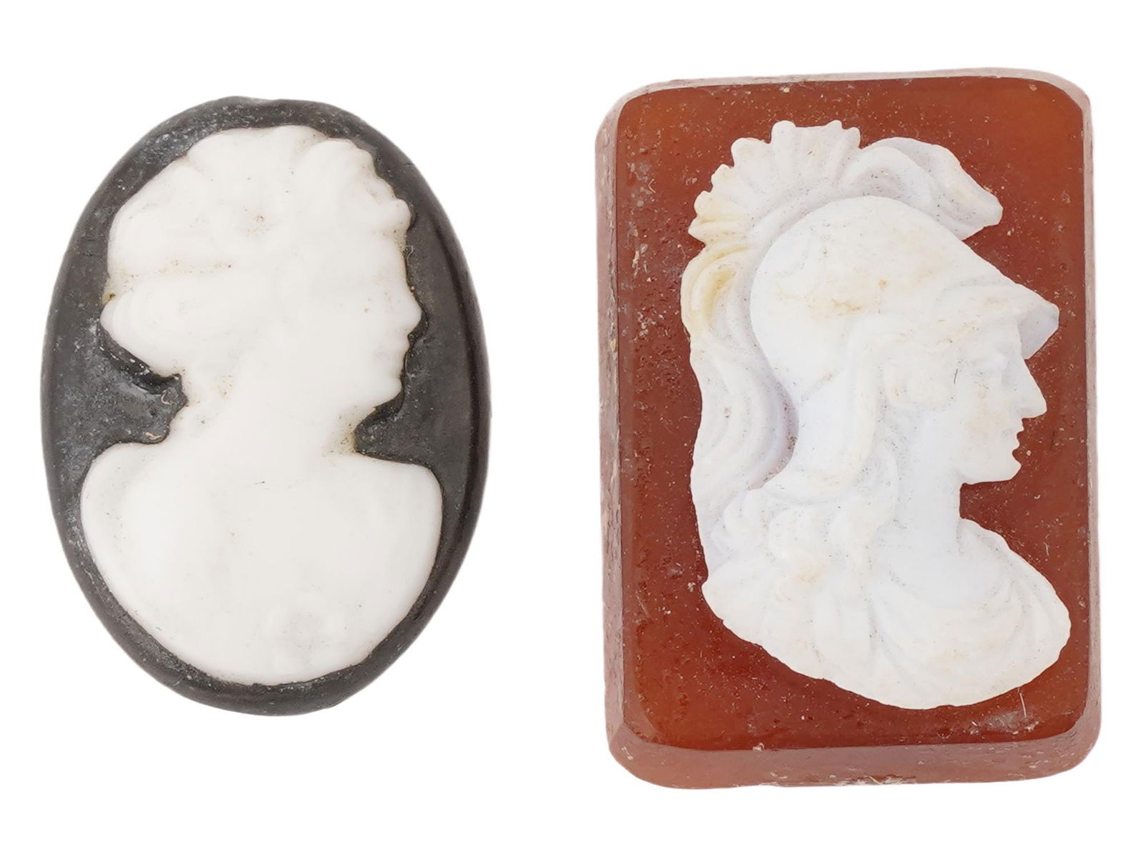ANTIQUE SHELL CAMEOS FEMALE AND WARRIOR HEAD PORTRAITS: A lot of two antique shell cameos. The first cameo is oval and depicts a womans profile facing right. The second cameo is rectangular and depicts the profile of an ancient warrior wearing a high helme