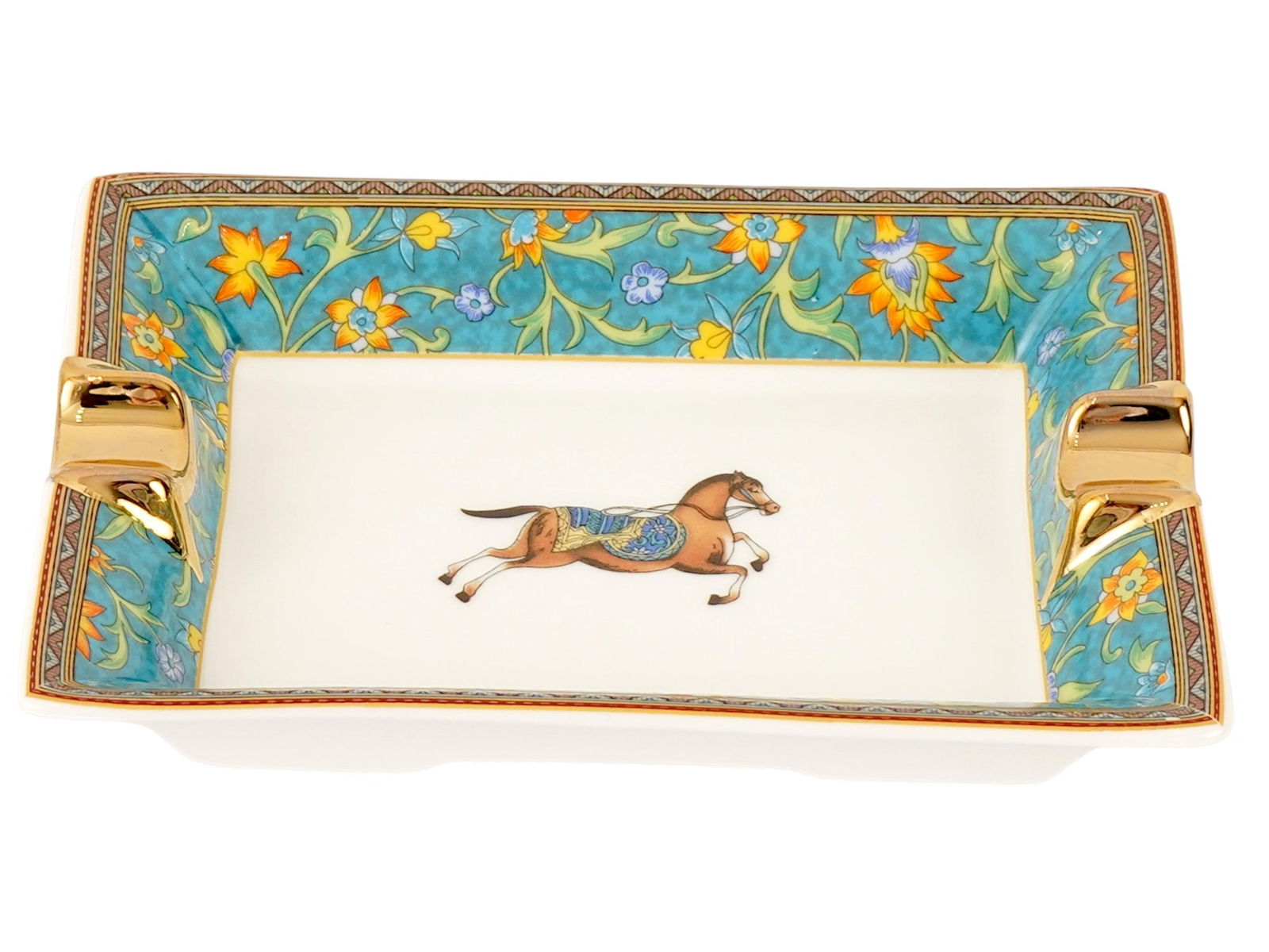 VINTAGE HERMES CHEVAL DORIENT GILT PORCELAIN ASHTRAY: A vintage Hermes Cheval dOrient porcelain ashtray, inspired by 15th- and 16th-century Persian miniatures and the brands equestrian heritage. The design features an intricate hand-applied screen print