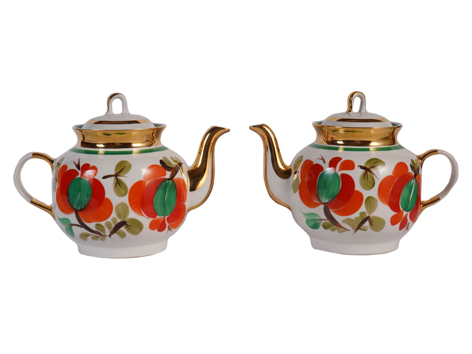 PAIR OF SOVIET ERA HAND PAINTED FLORAL TEAPOTS CHAIKA: A pair of Soviet-era teapots features the distinctive design, characterized by bold, hand-painted floral motifs and rich gilded accents. Both are marked with a stylized image of a blue flying bird on