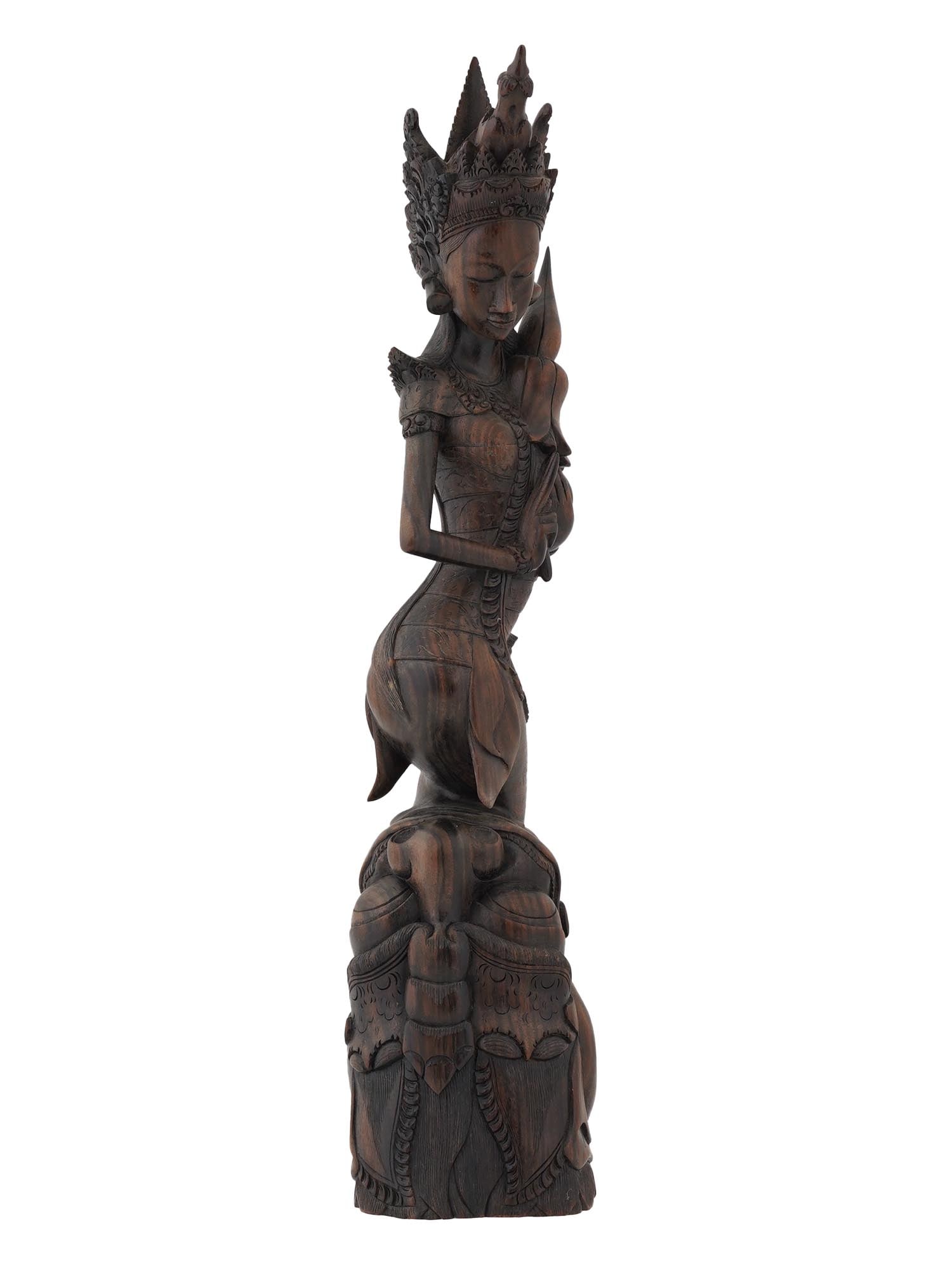 BALINESE HAND CARVED WOOD FIGURE OF DEWI RATIH: A Balinese hand carved wood figure of Dewi Ratih. The highly detailed and finely crafted sculpture of a goddess in a complex pose with a high crown and her hands folded in the Jegeg gesture, which sig