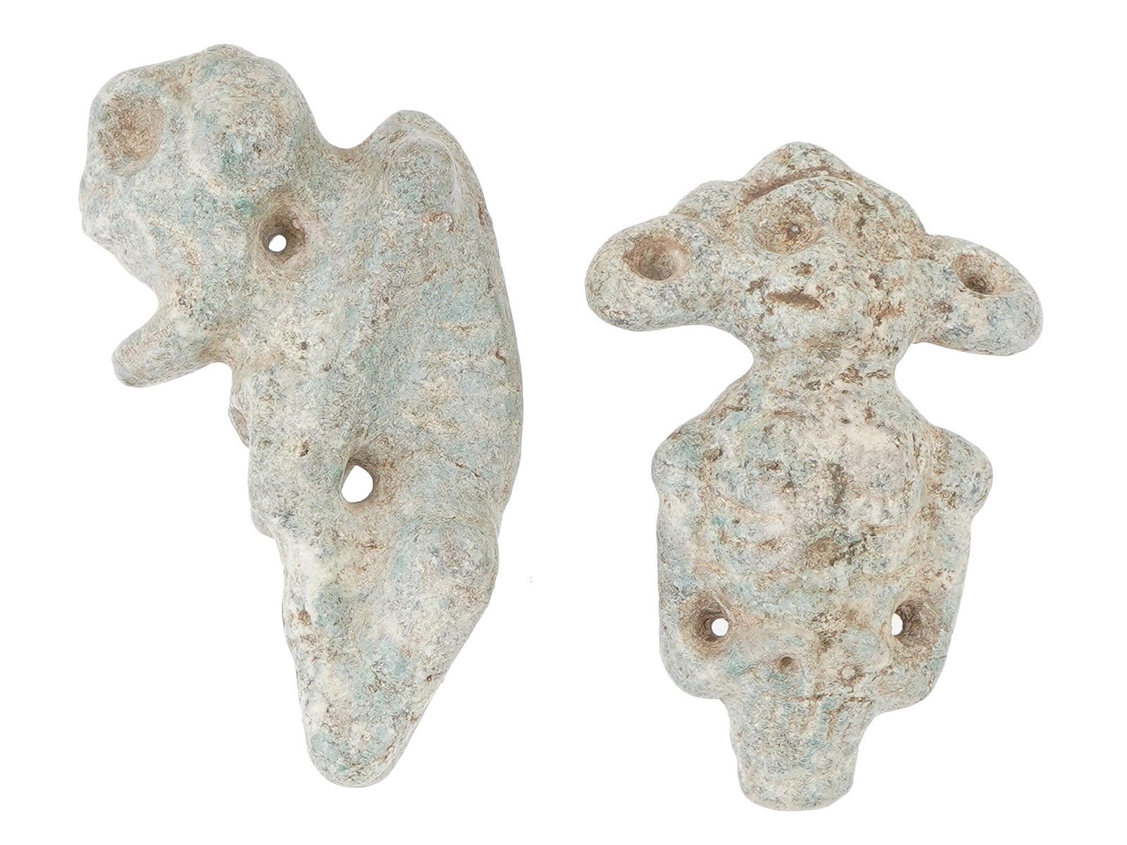 TWO ANCIENT CARVED GREENSTONE AMULET PENDANTS: A lot of two ancient carved greenstone amulet pendants. The pendants feature anthropomorphic figures decorated with carved ornaments. Both have holes through them. Historical Finds And Archaeological