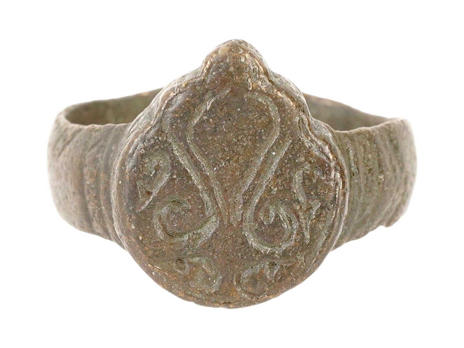ANCIENT ROMAN EMPIRE ENGRAVED BRONZE SIGNET RING: An Ancient Roman bronze signet ring featuring a prominent shield shaped bezel. Imperial Rome era, 100 to 300 AD. The bezel is shaped like a heraldic shield or a teardrop with an engraved heart motif,