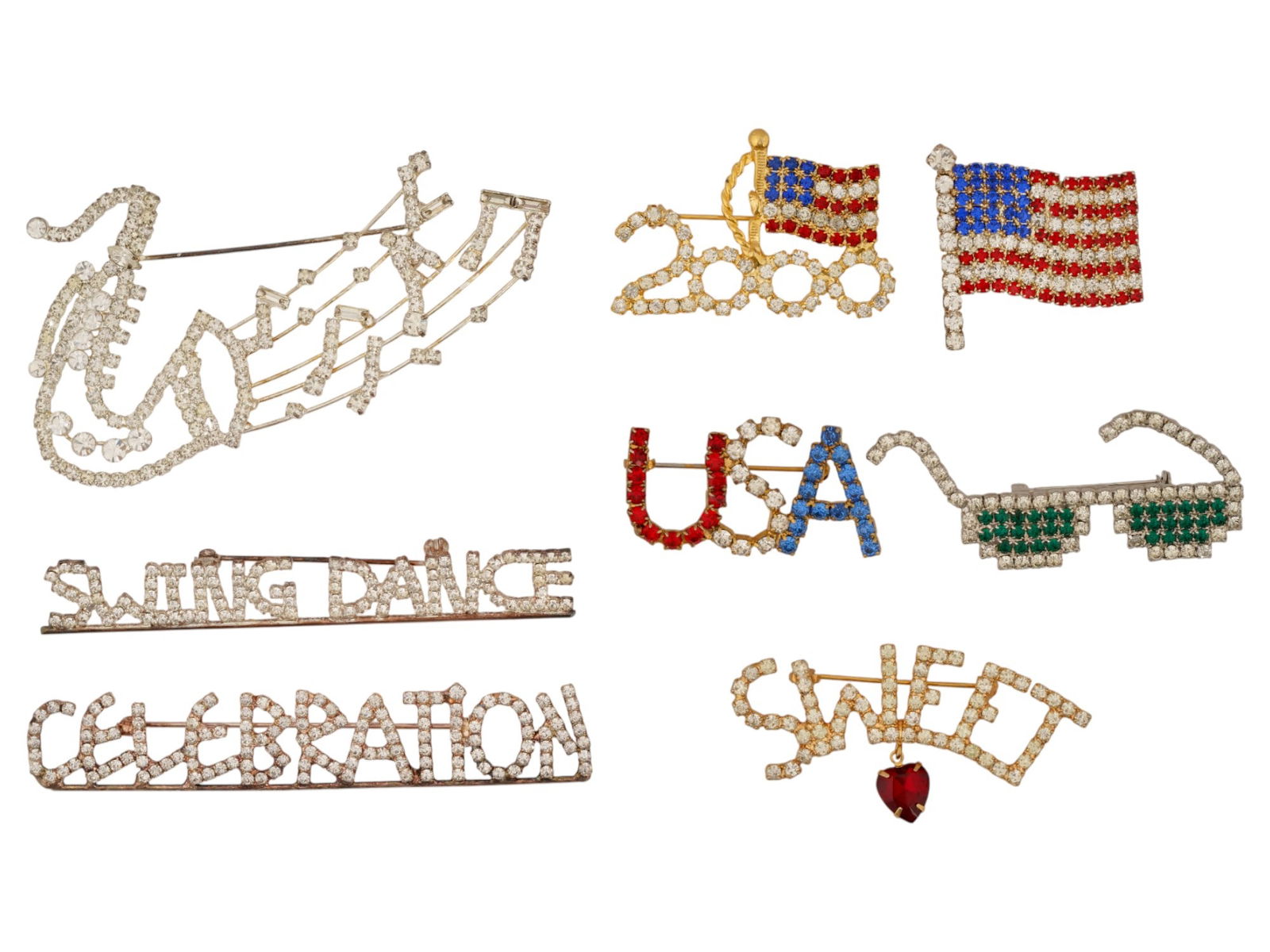 GROUP OF EIGHT VINTAGE COSTUME JEWELRY BROOCHES: A group of eight vintage American pieces of costume jewelry brooches adorned with multicolor rhinestones. These items feature American patriotic and music-themed designs. Vintage Costume Brooches And