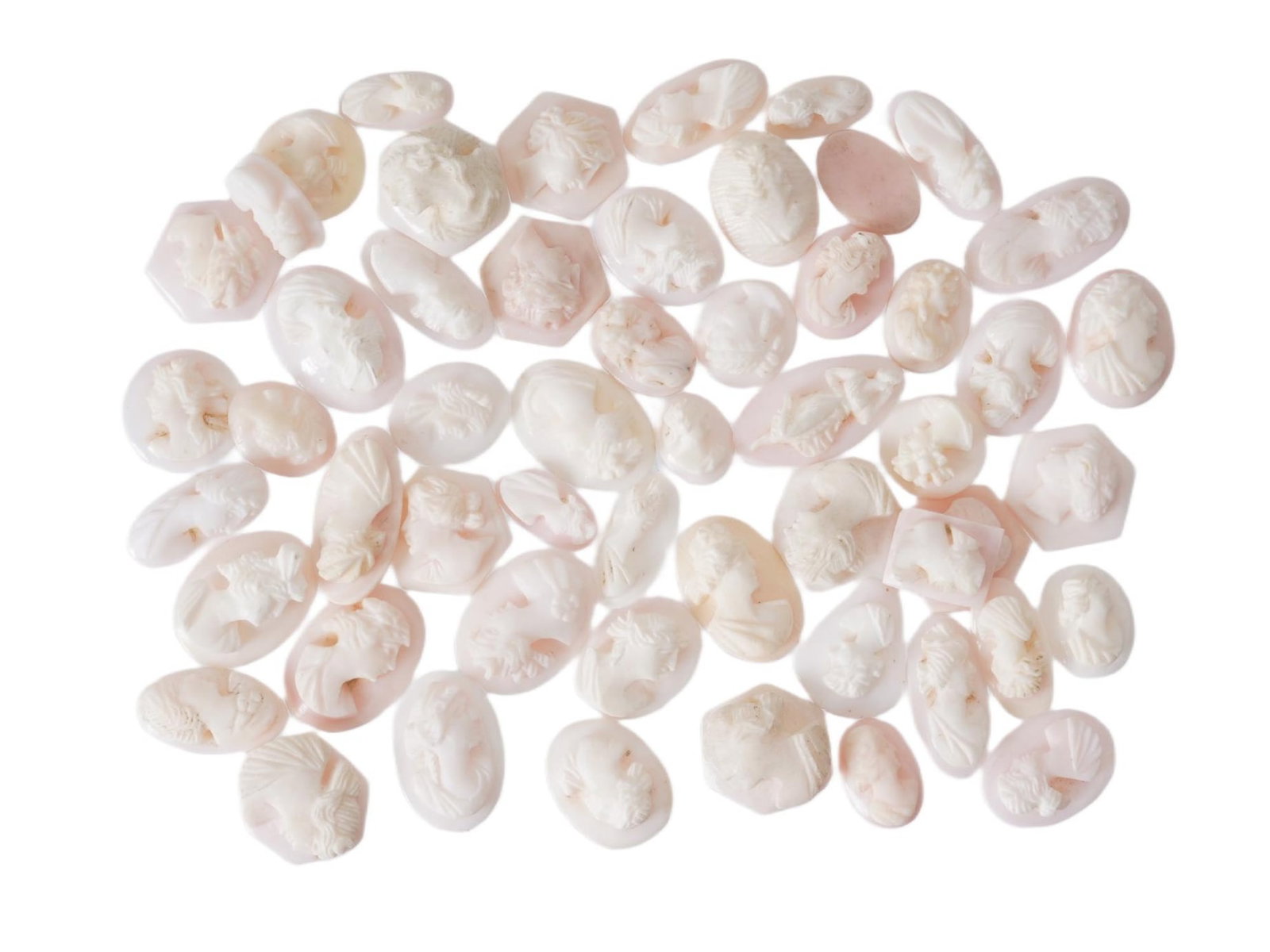 COLLECTION OF 54 CARVED CORAL CAMEOS W FEMALE PROFILES: A collection of 54 hand carved coral cameos depicting female profiles in relief. These carvings are showcasing fine craftsmanship in depicting classical or neoclassical female silhouettes. Such cameos